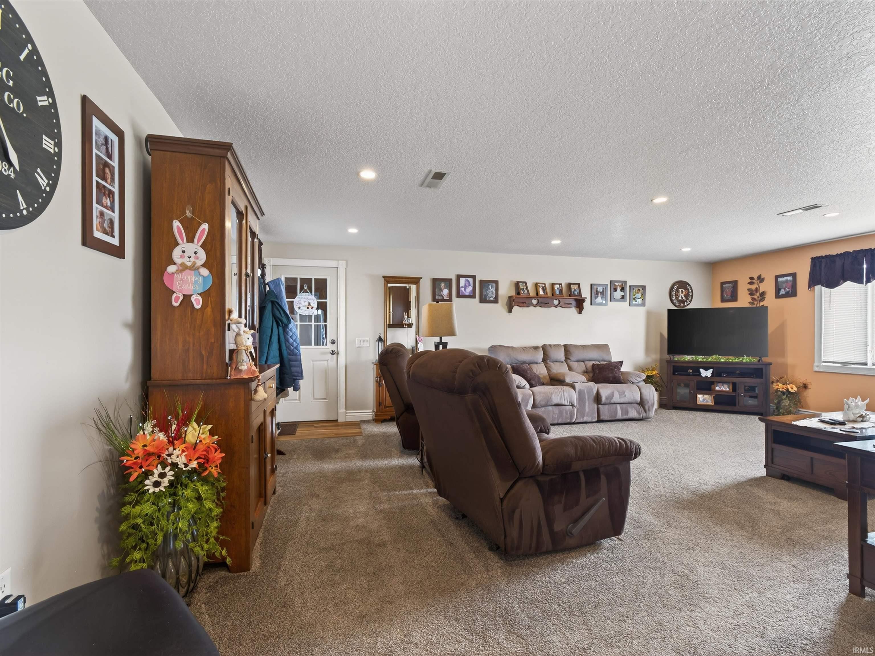 Living room featuring carpet flooring, recessed lighting, and a textured ceiling