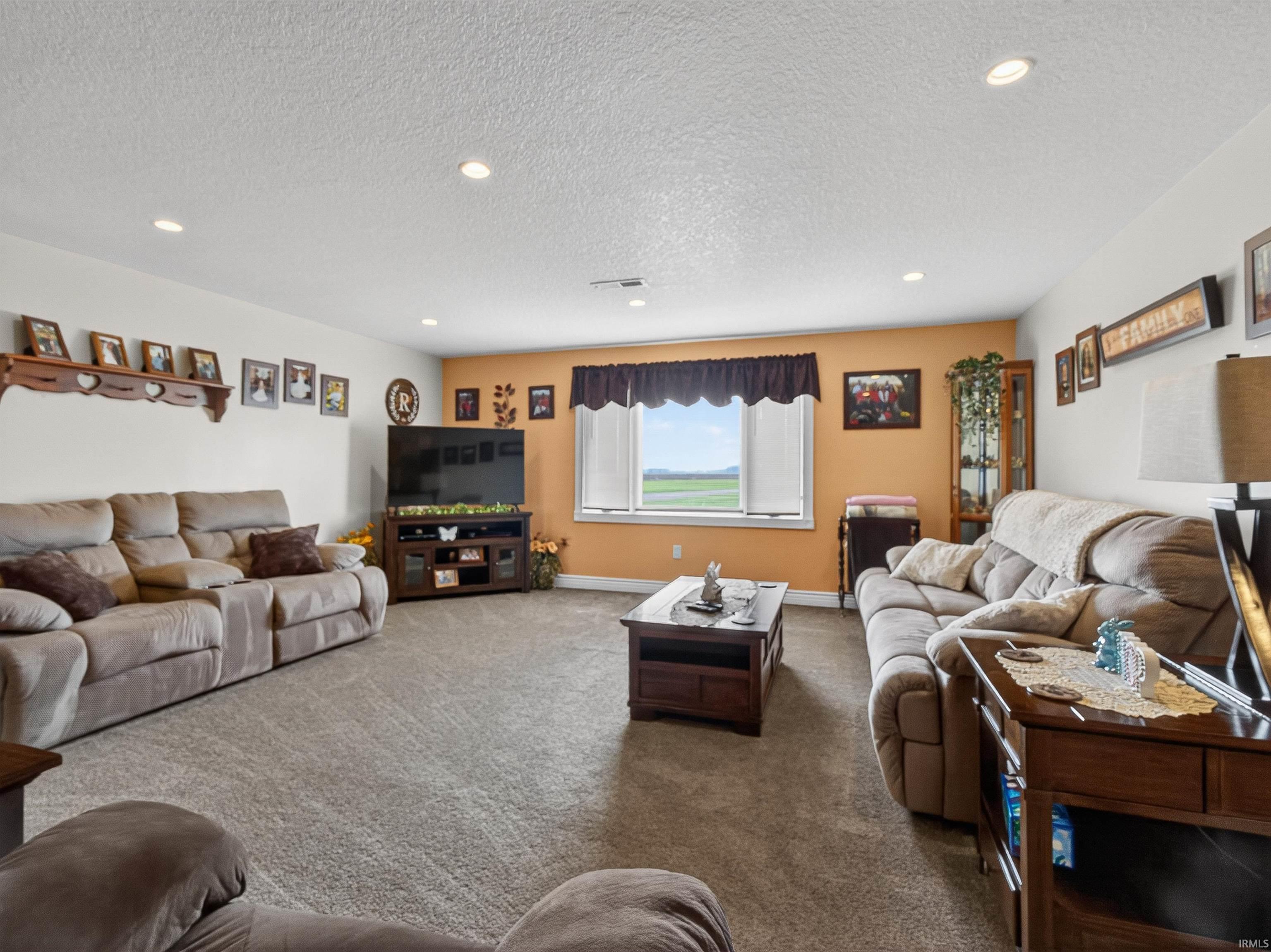 Living area featuring recessed lighting, carpet floors, and a textured ceiling