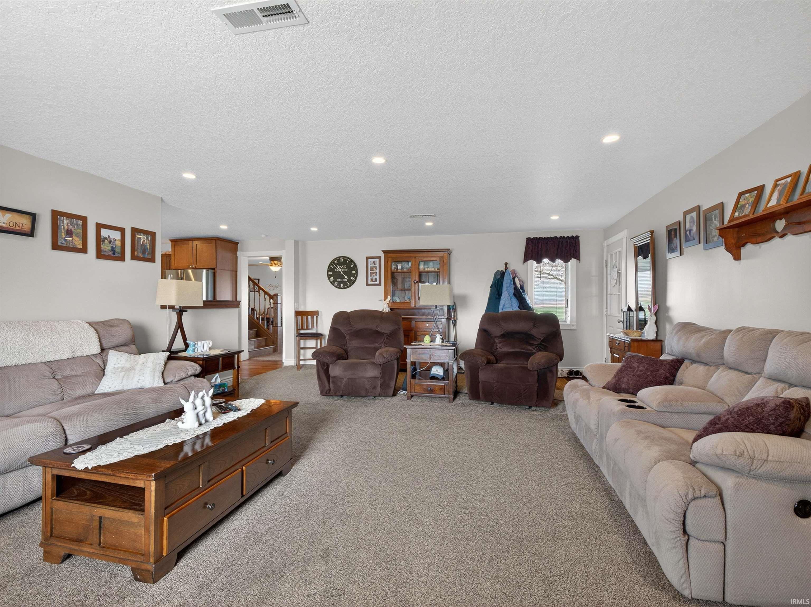 Living room featuring light carpet, recessed lighting, and a textured ceiling