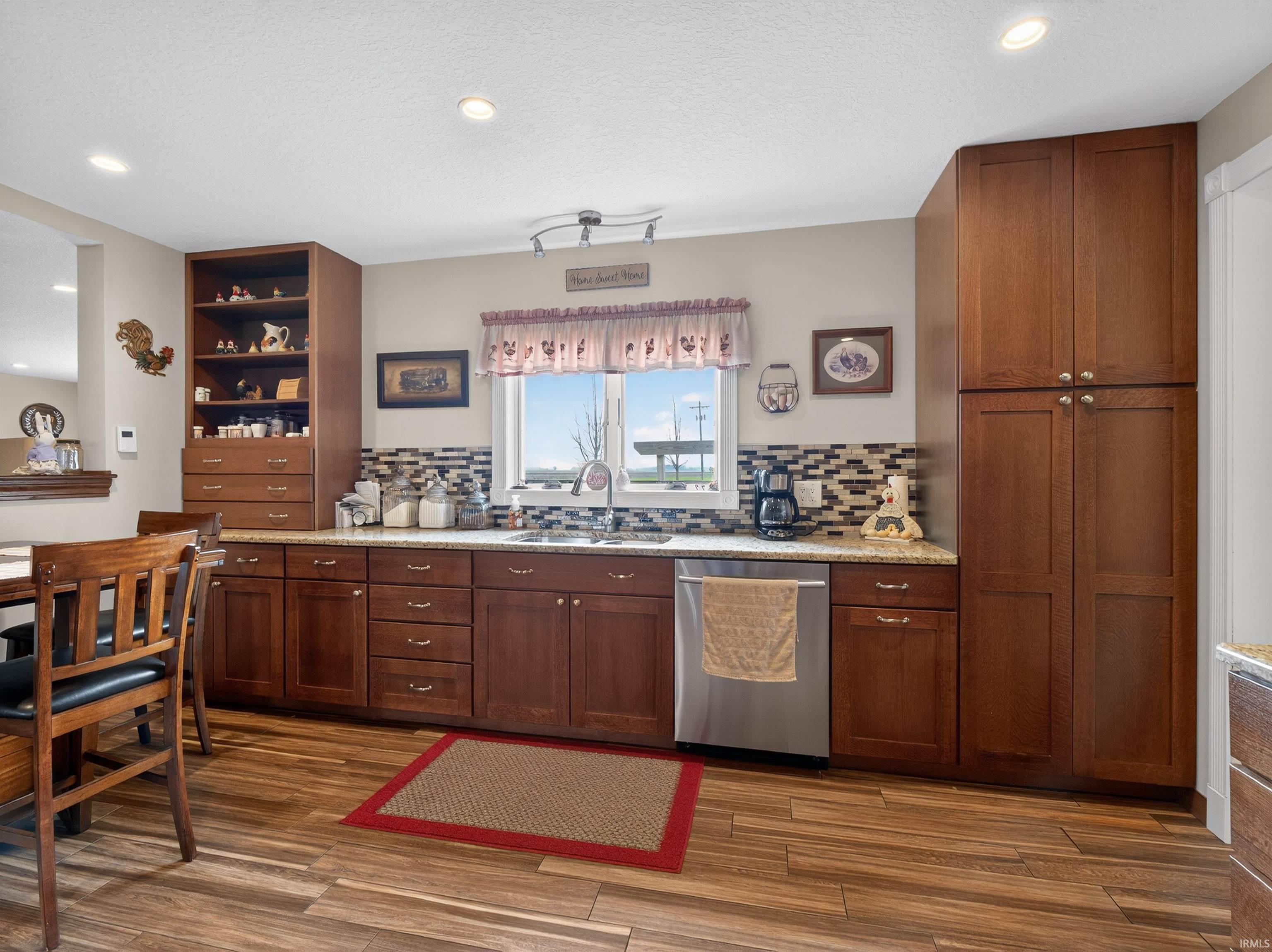 Kitchen featuring dishwasher, light stone counters, recessed lighting, decorative backsplash, and dark wood-style flooring