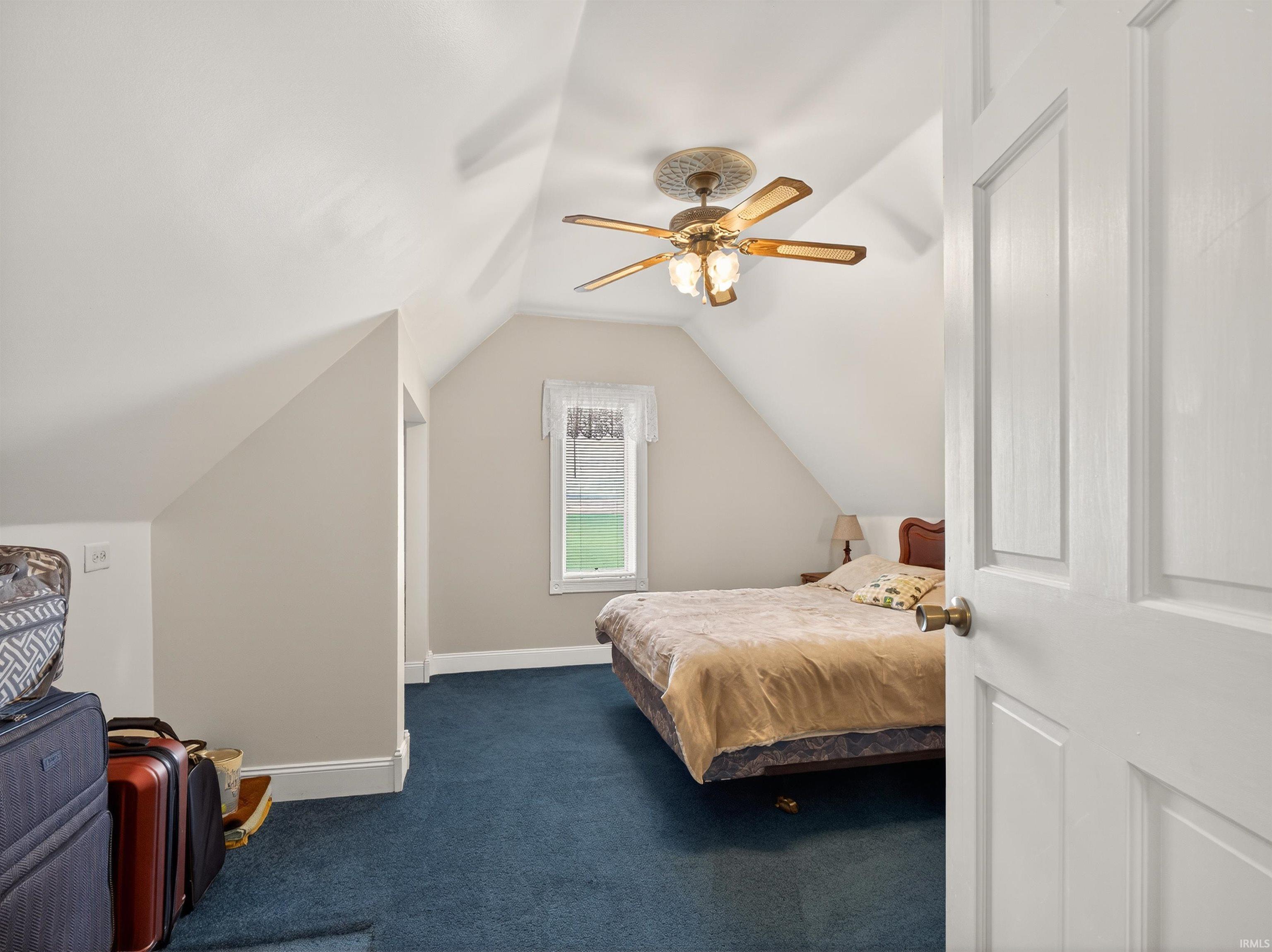 Bedroom with dark colored carpet and ceiling fan