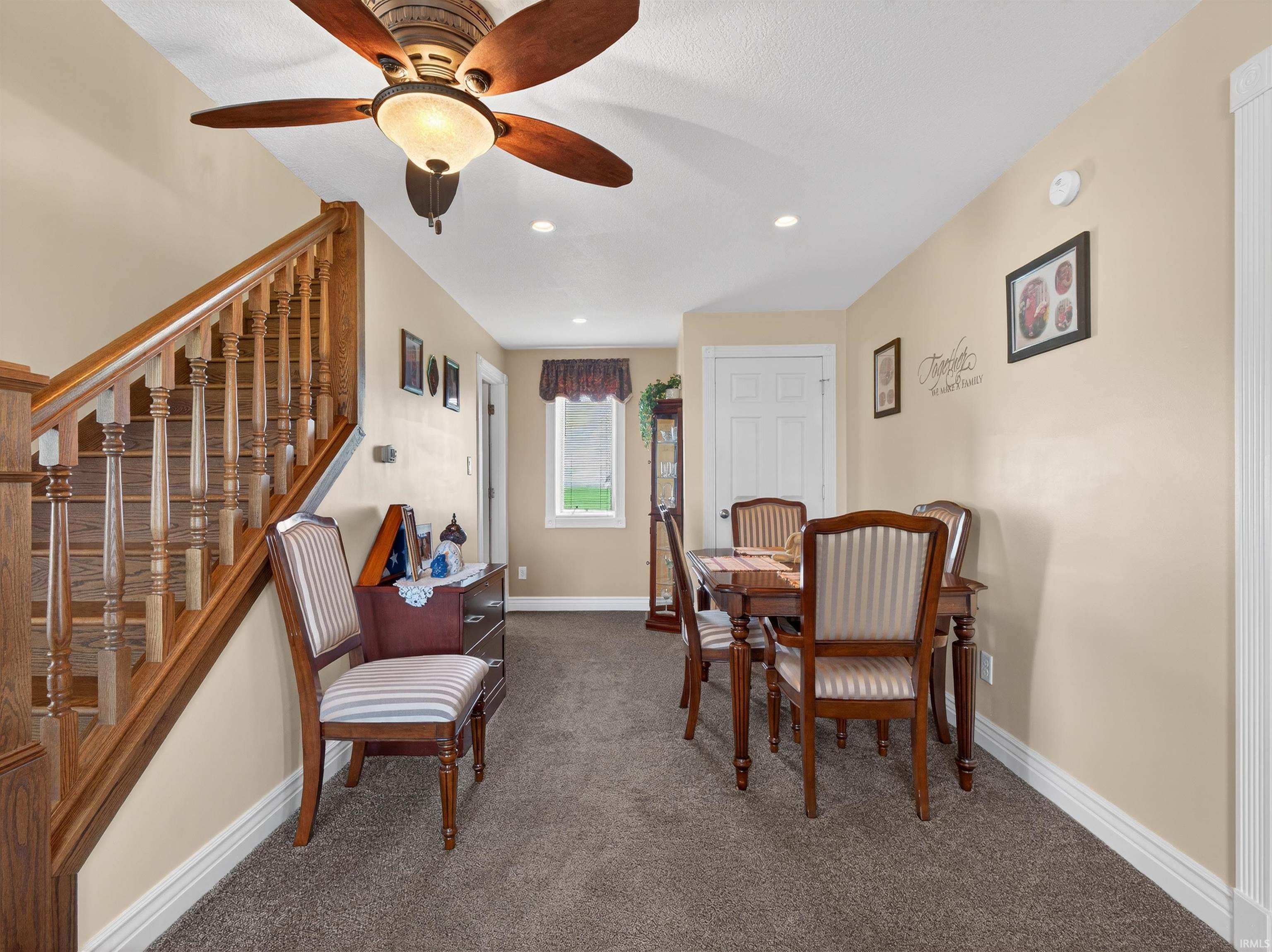 Dining space with dark colored carpet, ceiling fan, and recessed lighting