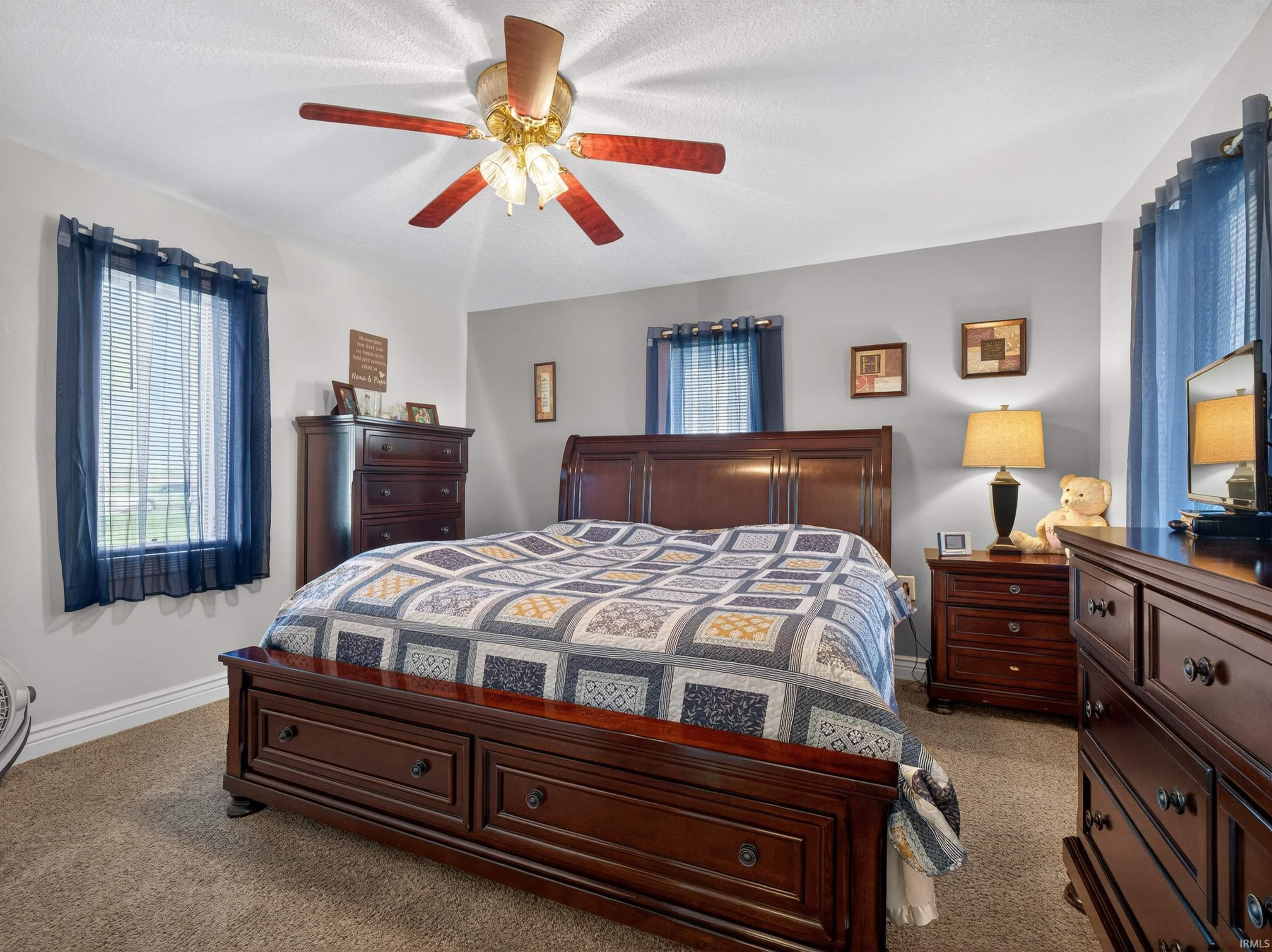 Bedroom with a ceiling fan and light colored carpet