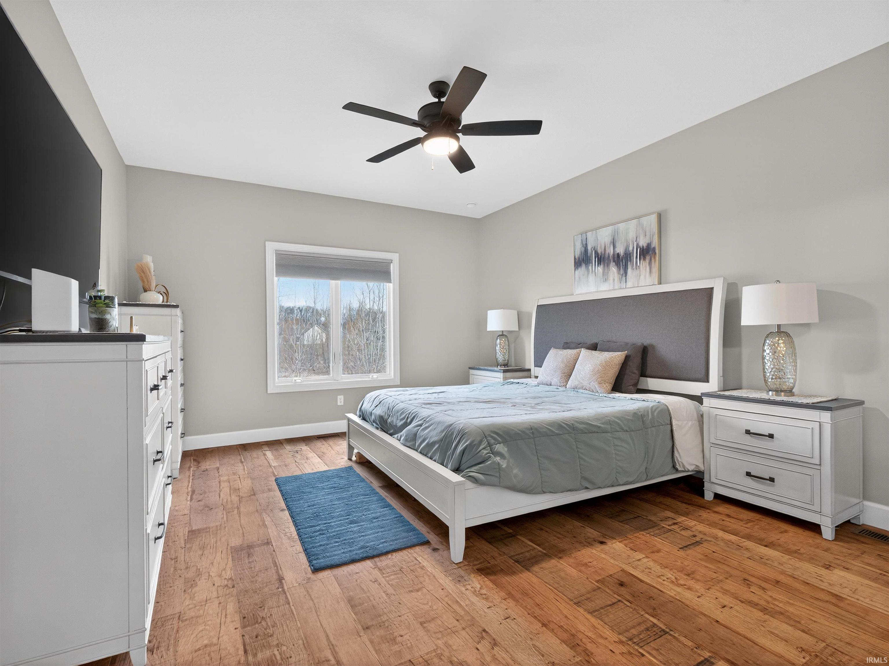 Bedroom with light wood-style floors and a ceiling fan