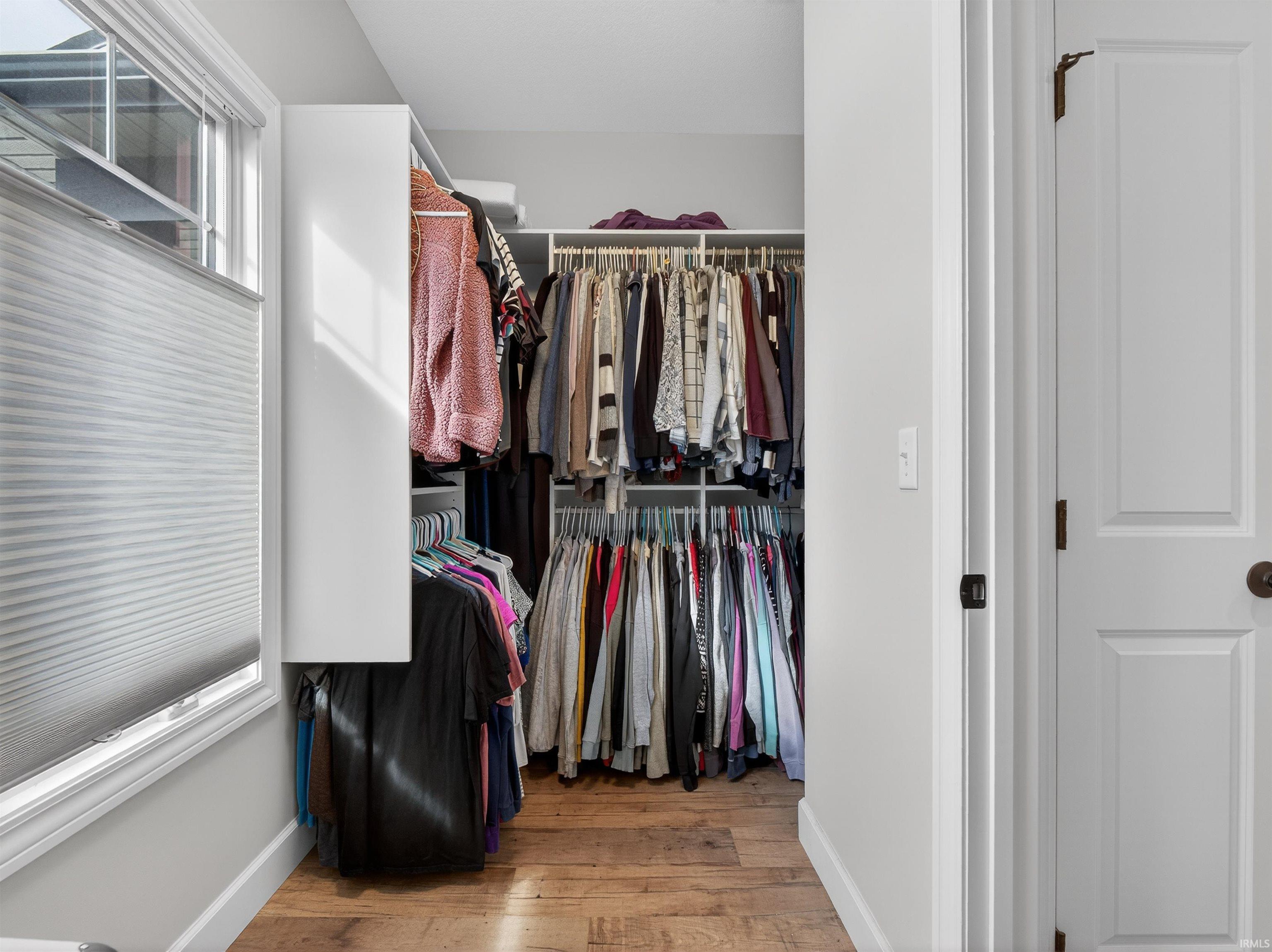 Walk in closet with light wood-type flooring