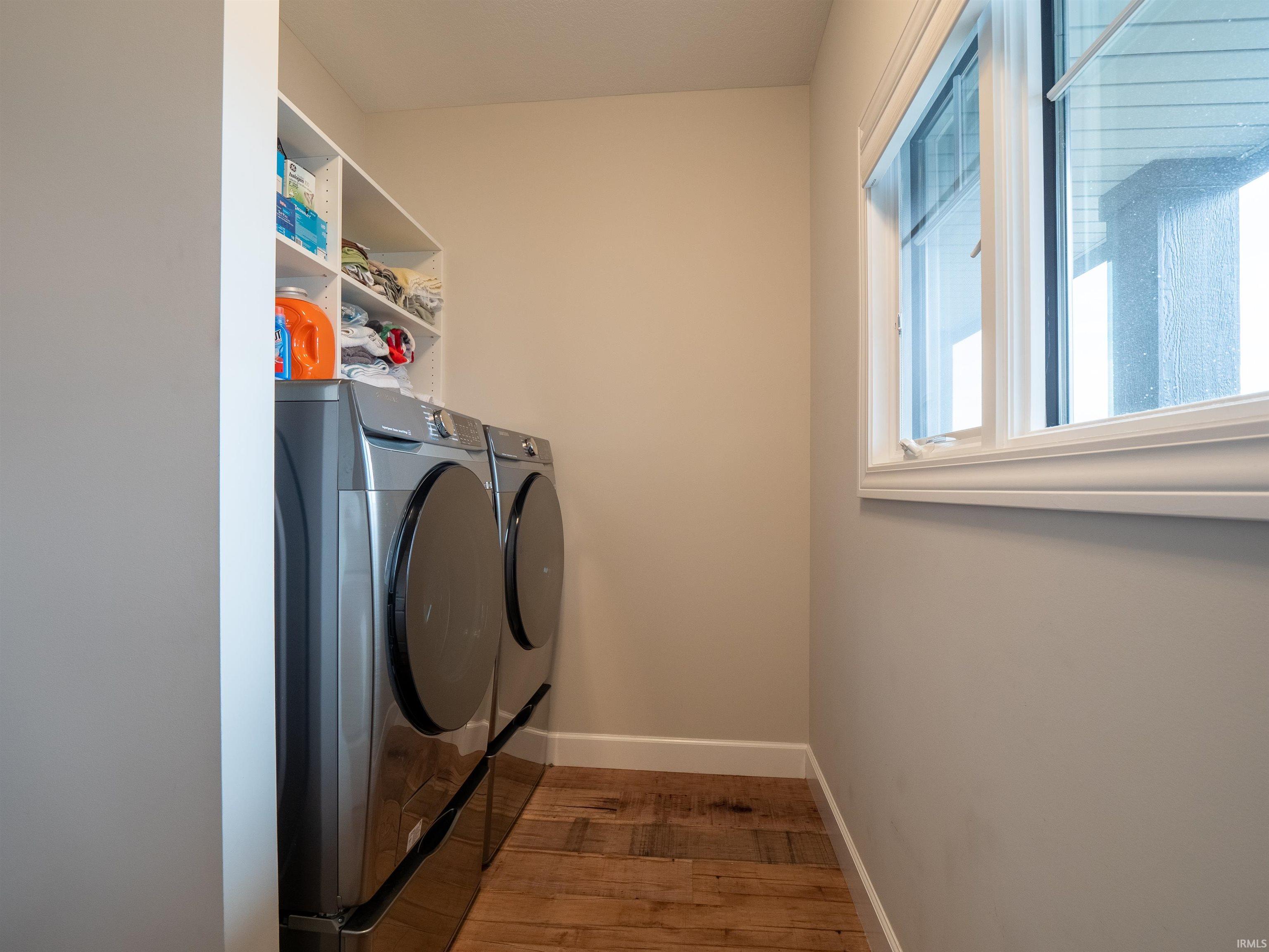 Laundry area featuring light wood-style floors and washing machine and clothes dryer