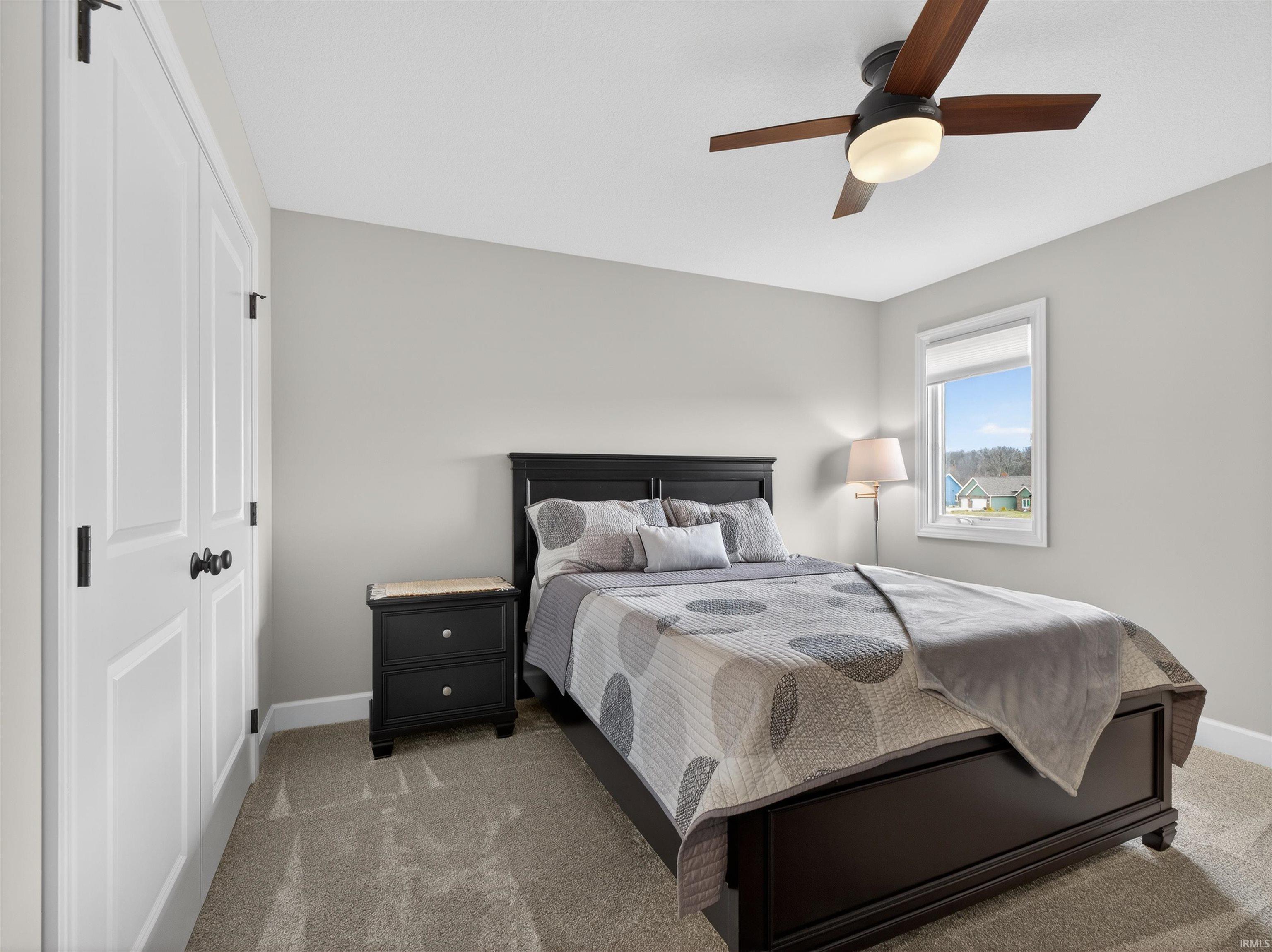 Bedroom featuring a closet, ceiling fan, and carpet