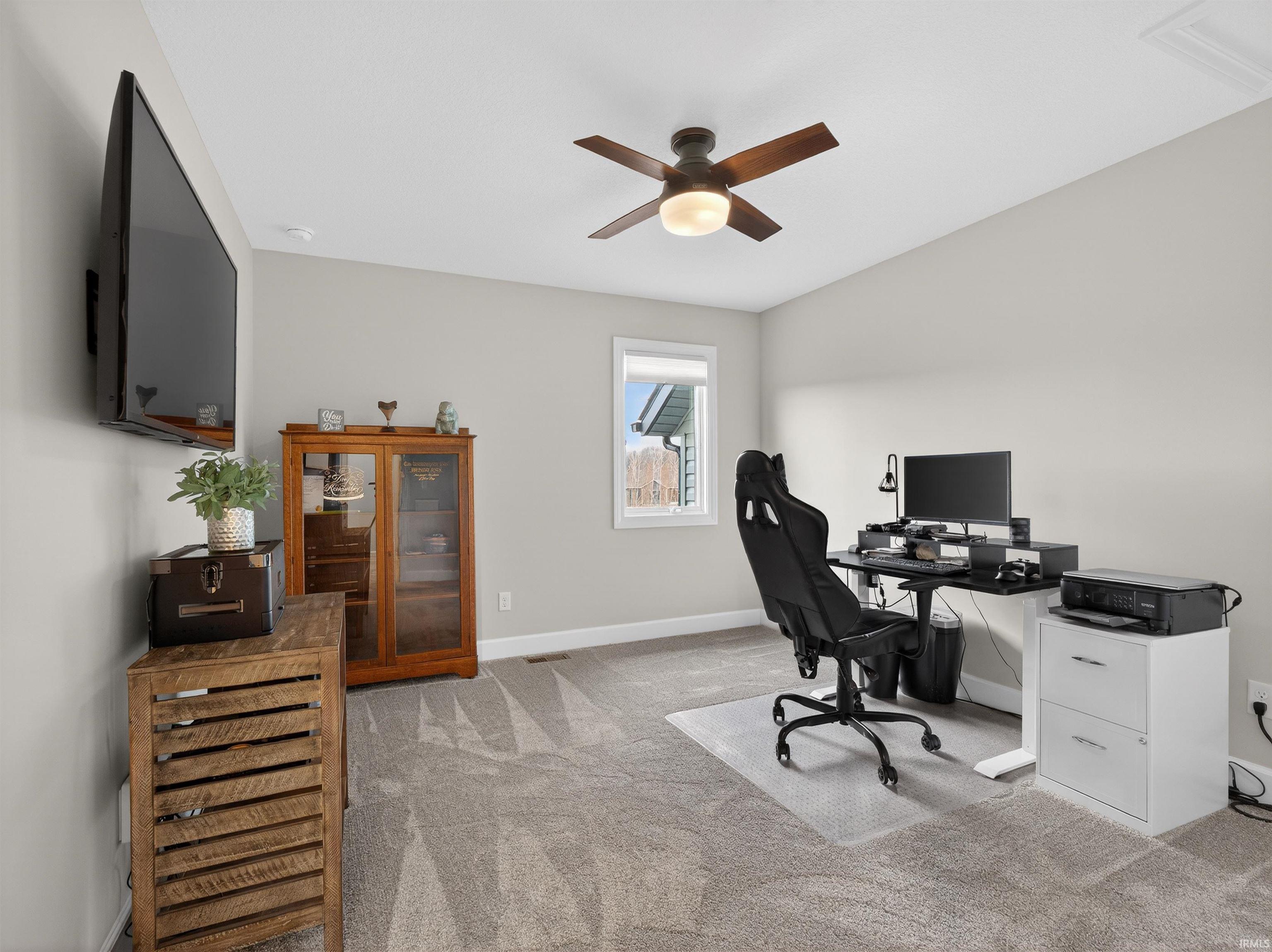 Office area featuring light carpet and ceiling fan