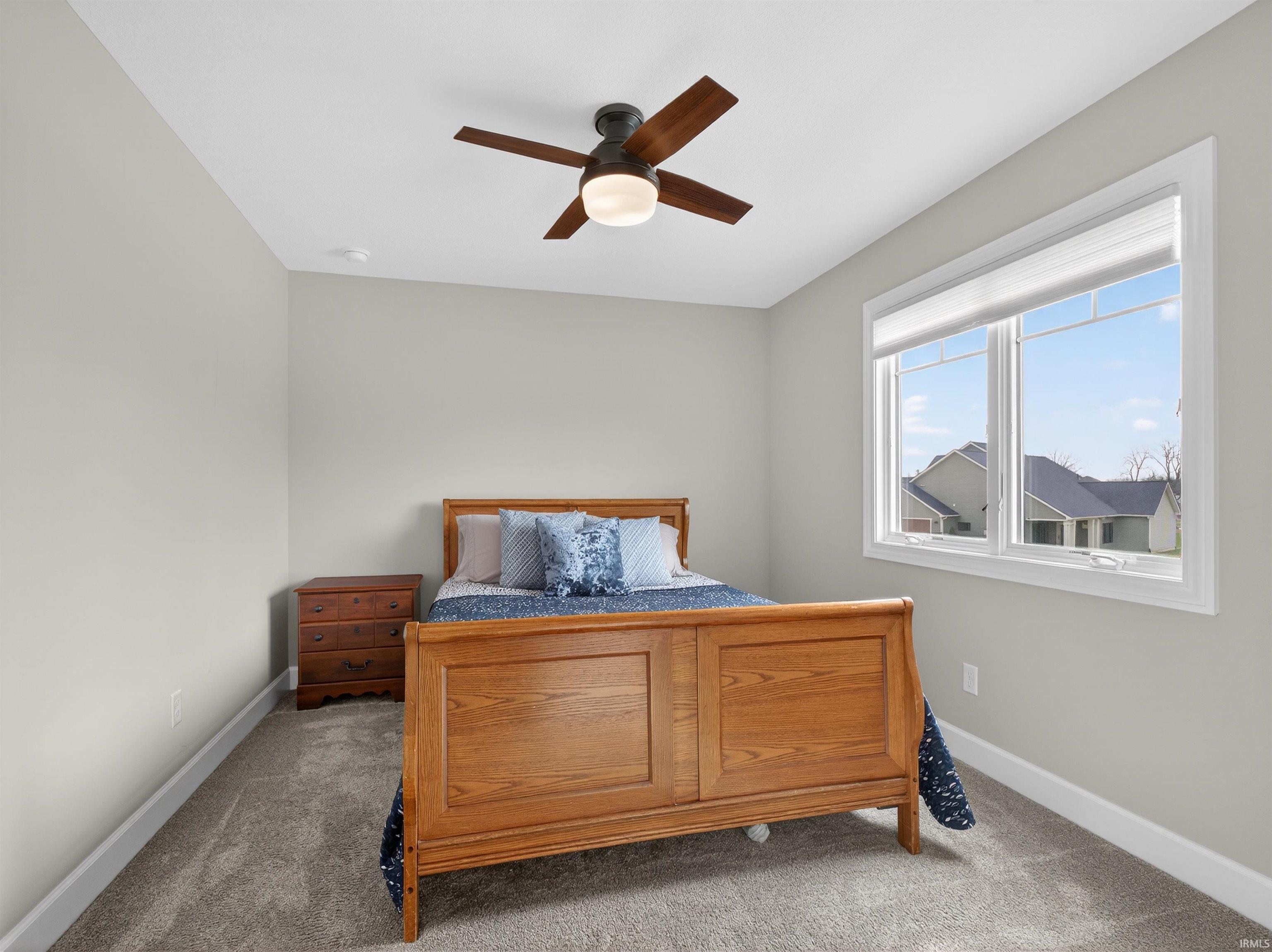 Carpeted bedroom with baseboards and a ceiling fan