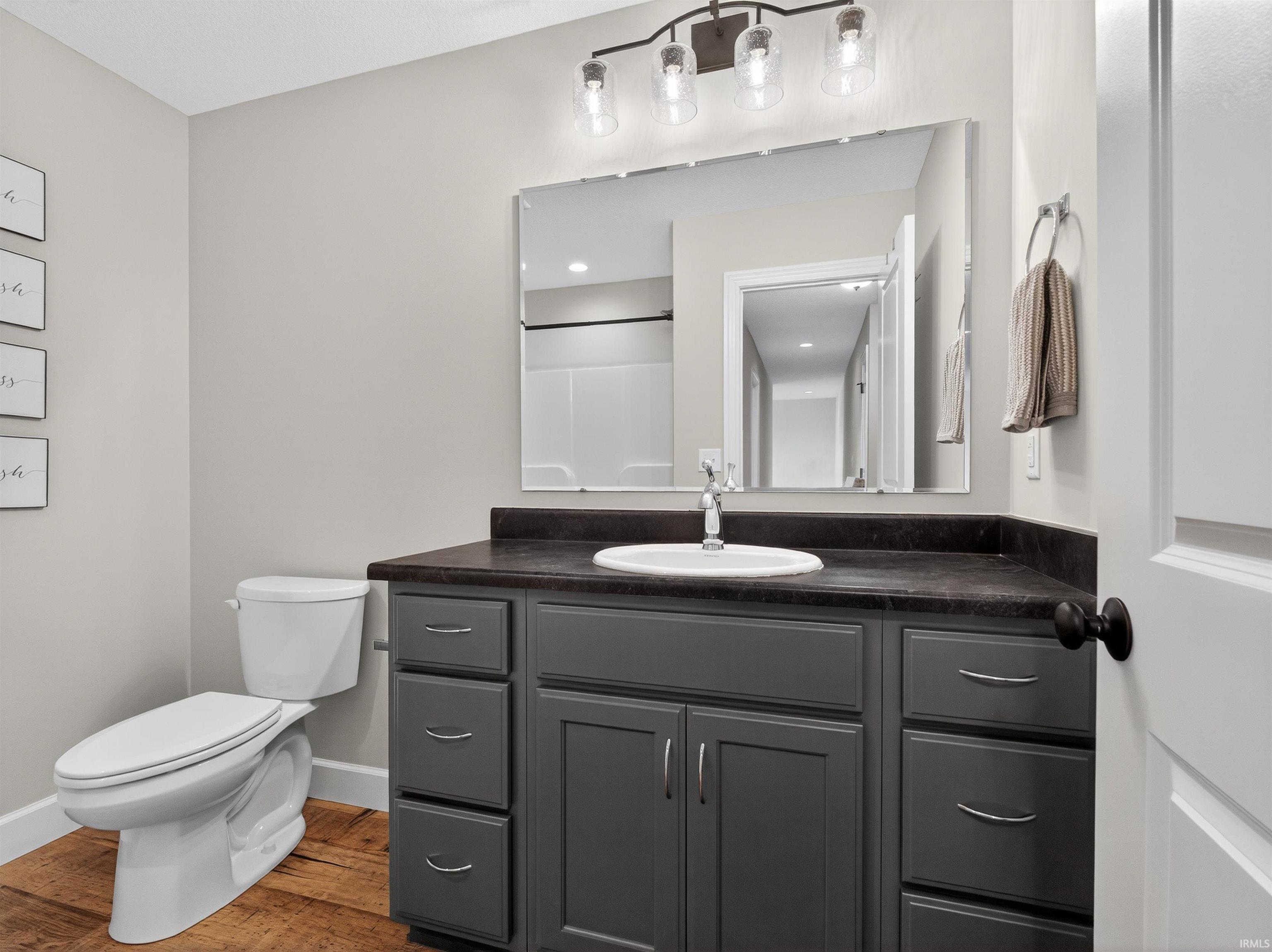 Bathroom with vanity, a shower, and dark wood-style floors