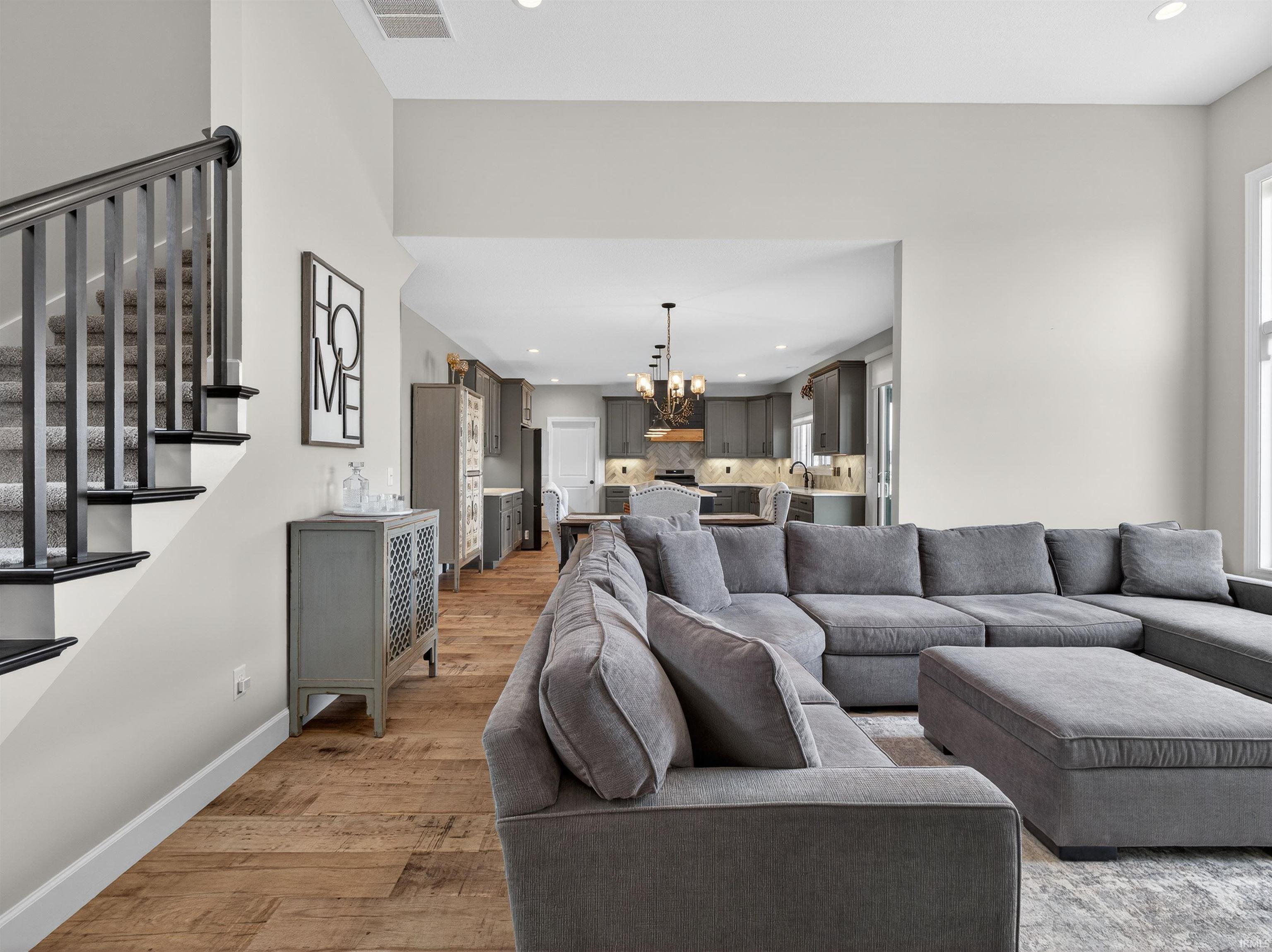 Living room with light wood-style floors and hanging lights