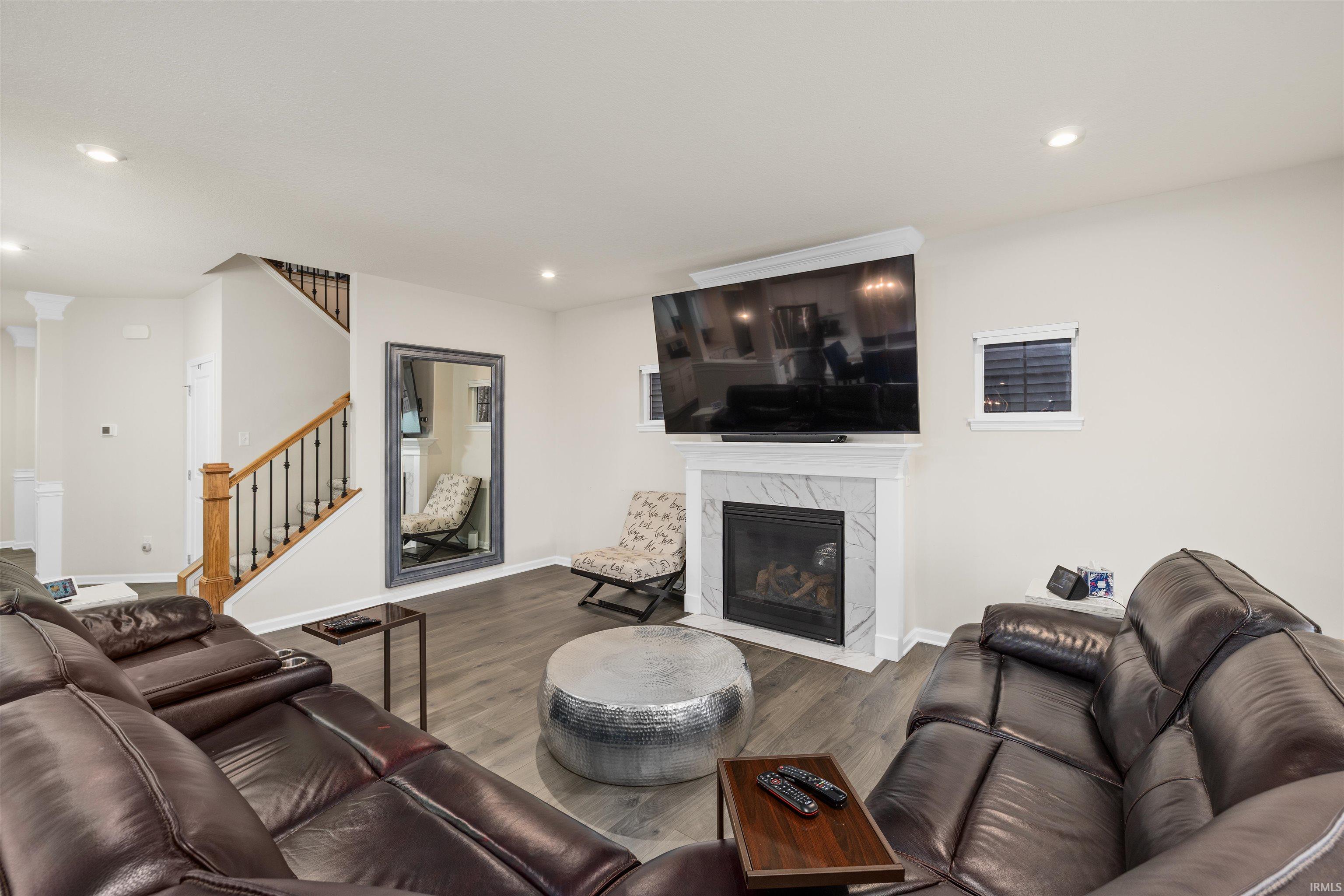 Living area with a premium fireplace, wood finished floors, and recessed lighting