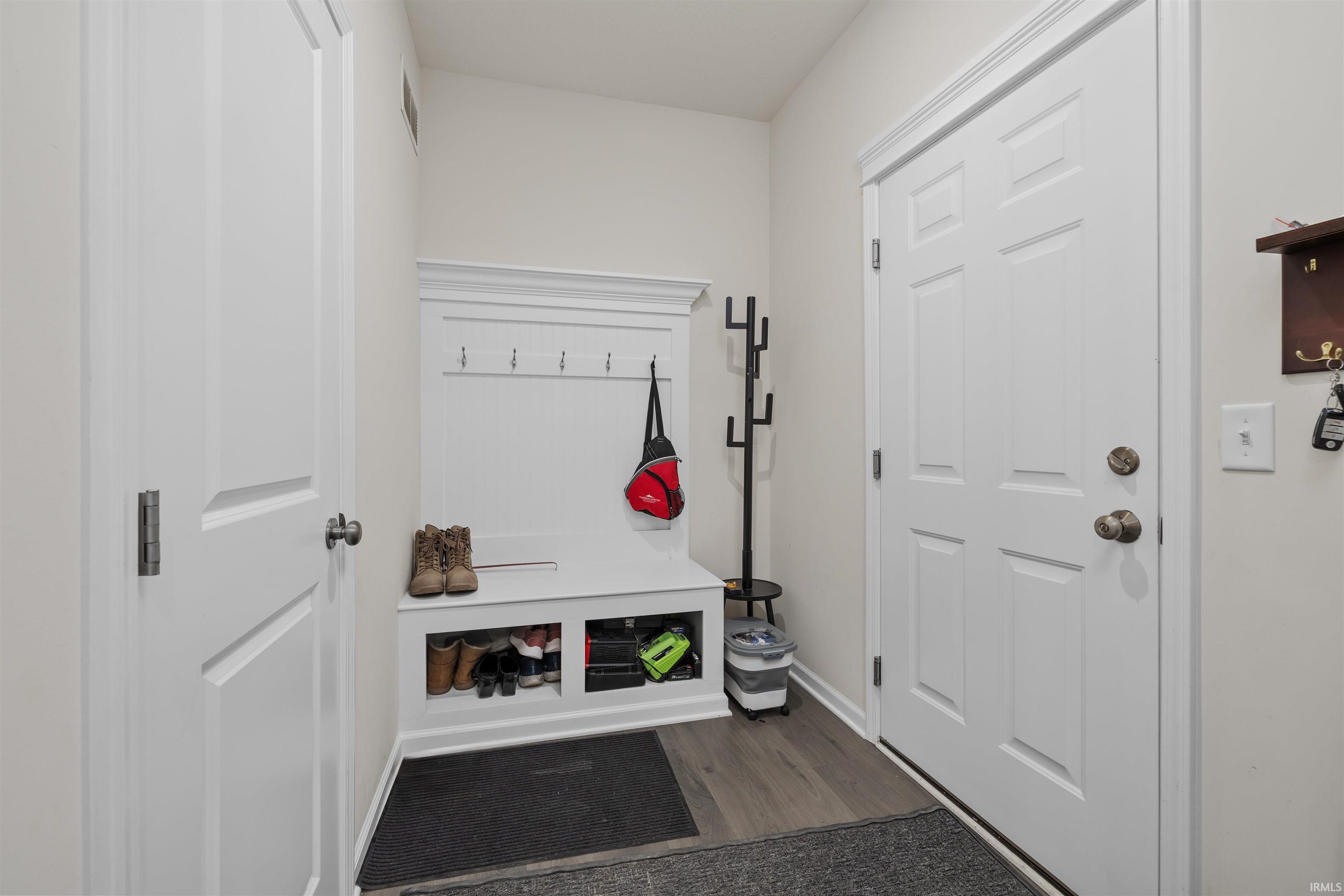 Mudroom with dark wood finished floors and baseboards