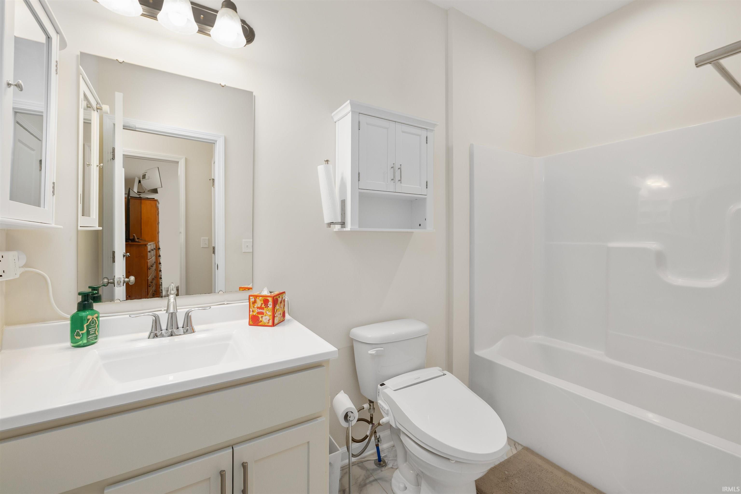 Full bath featuring vanity and shower / washtub combination