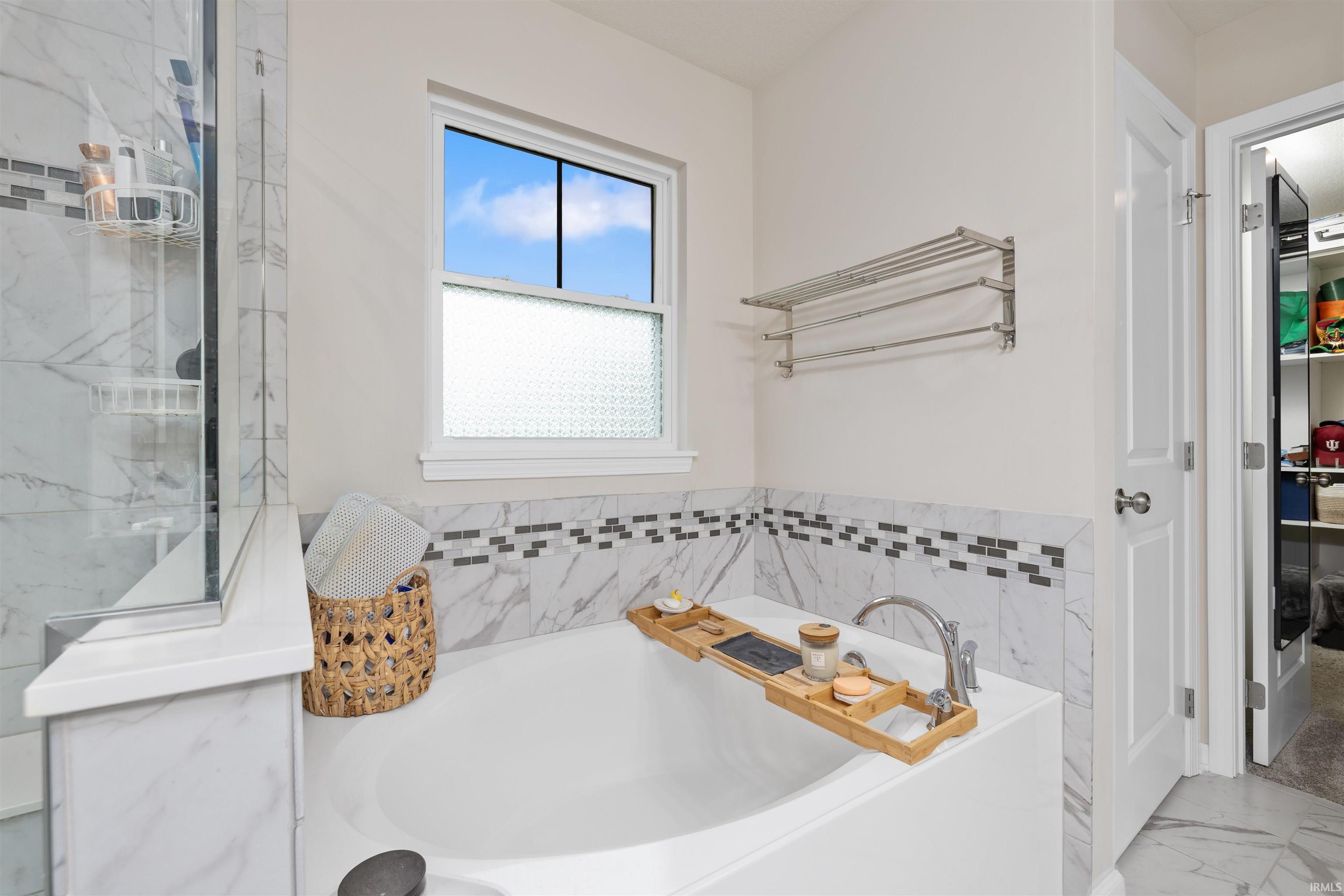 Bathroom featuring a bath and marble finish flooring