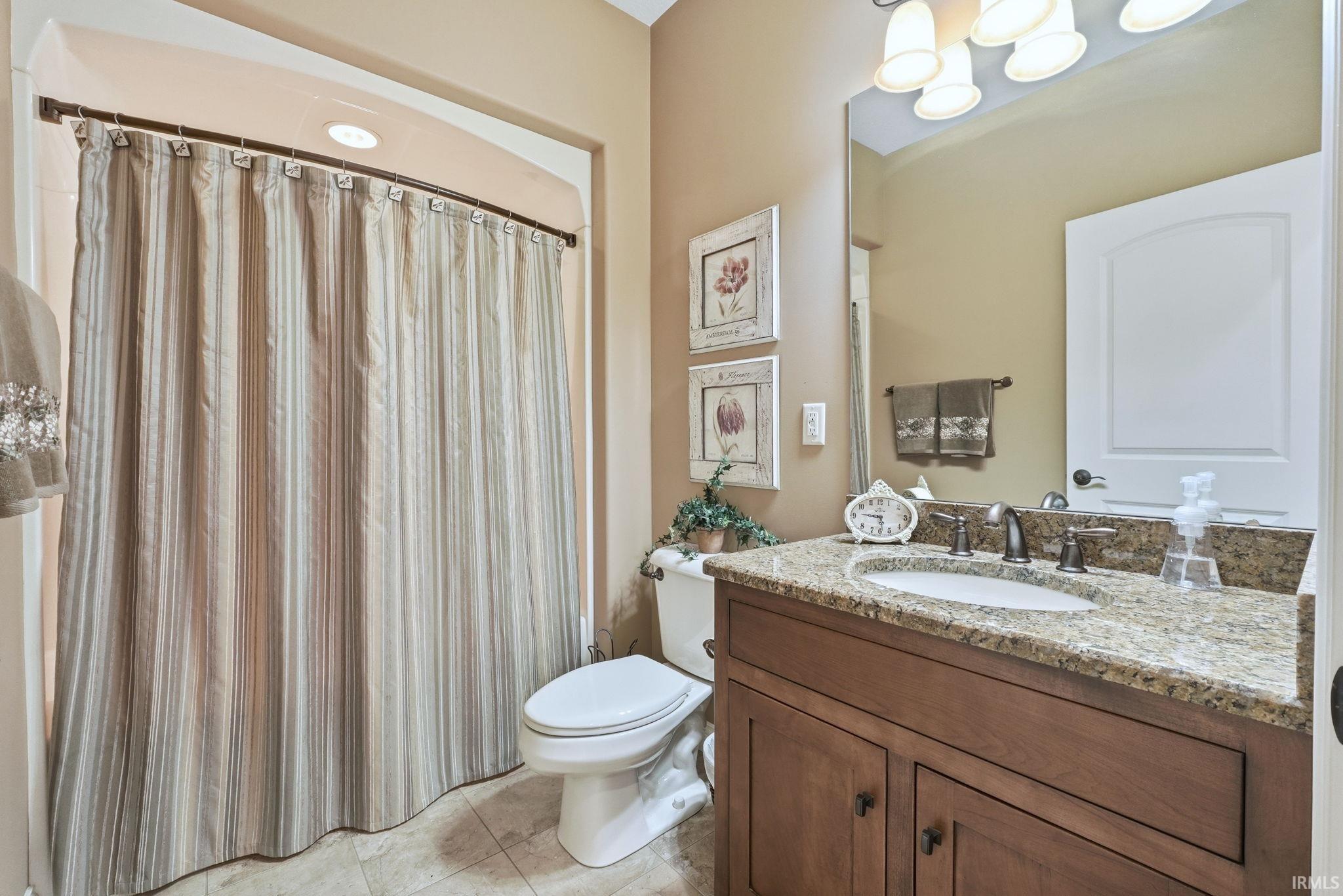 Full bath with vanity, a shower with shower curtain, and light tile patterned floors