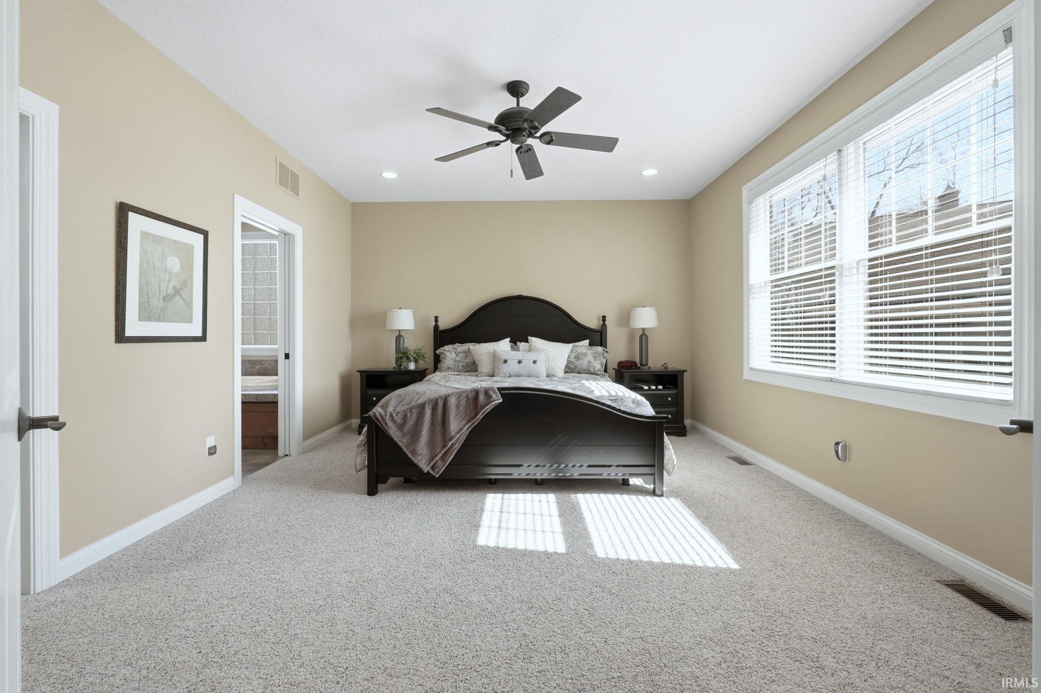 Bedroom featuring light carpet, ceiling fan, and recessed lighting
