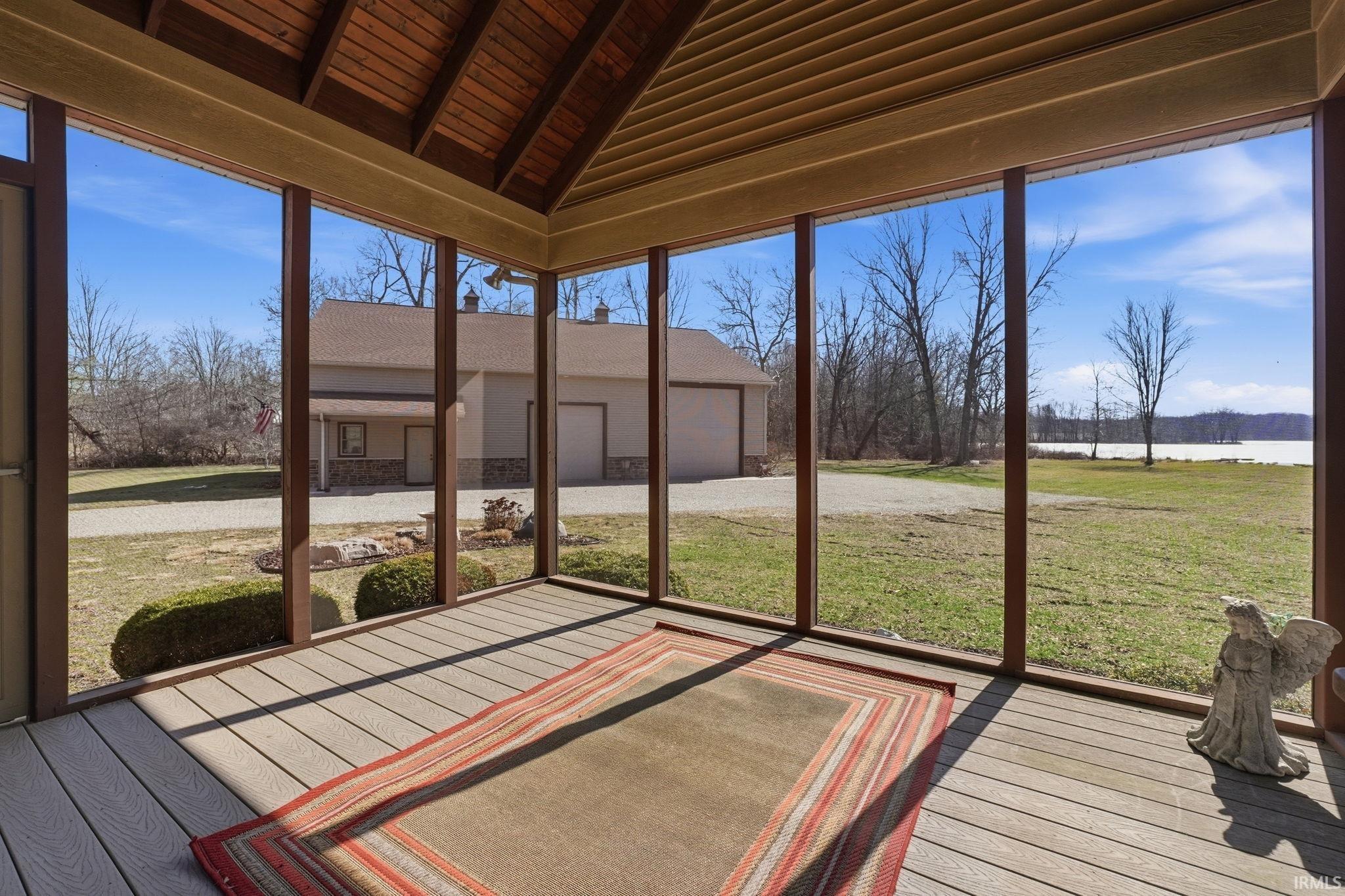 Unfurnished sunroom with lofted ceiling with beams and a water view