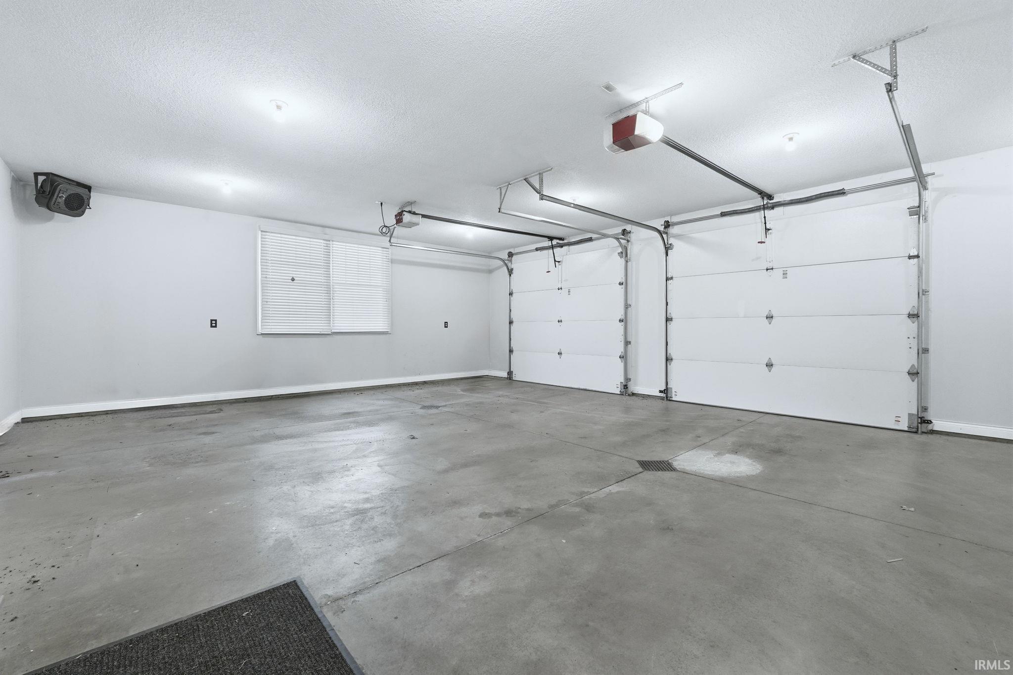 Garage with baseboards and a garage door opener