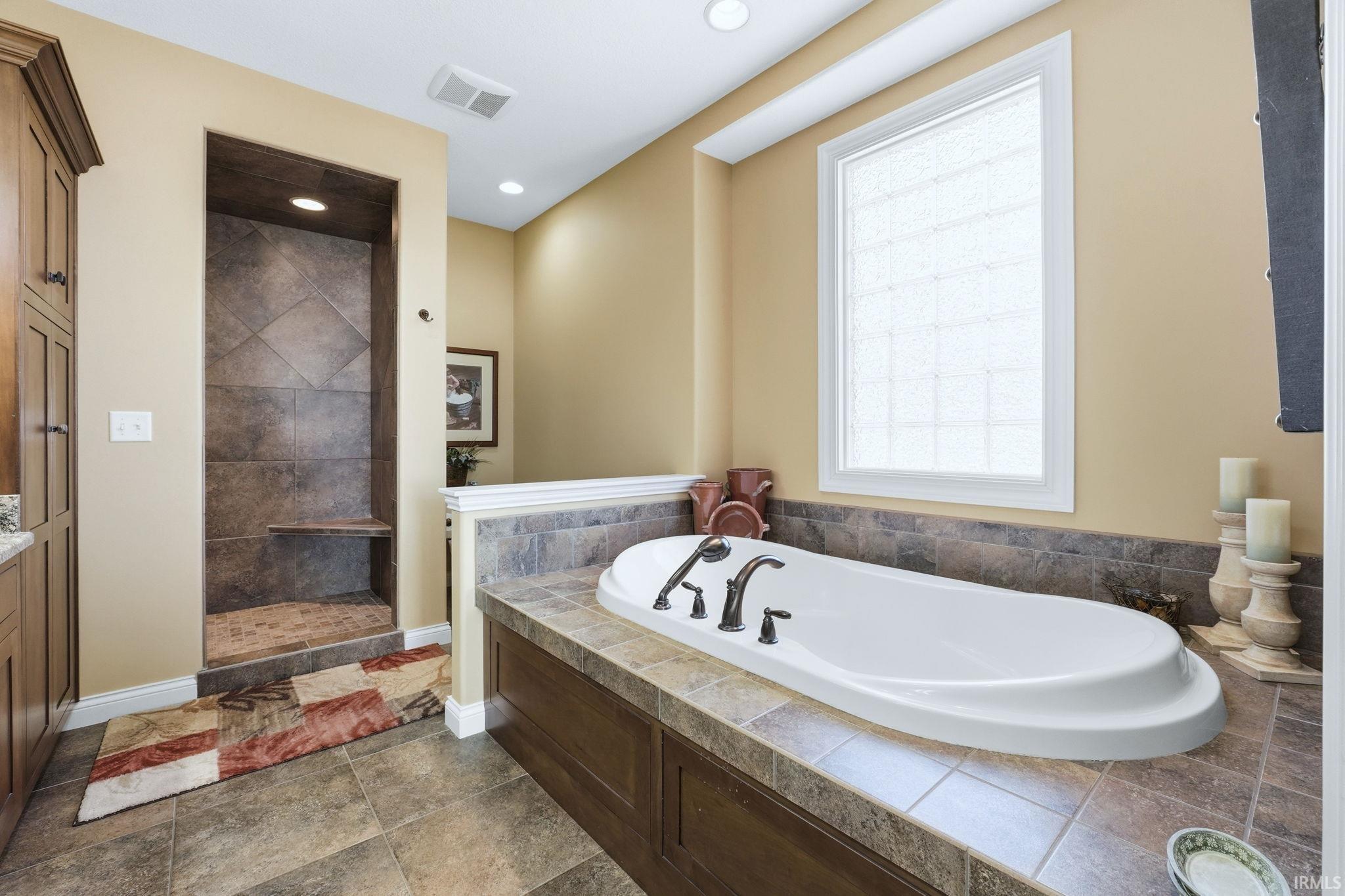 Full bath featuring walk in shower, a garden tub, vanity, and recessed lighting