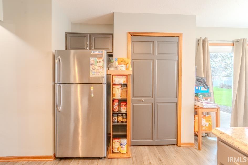 Kitchen with freestanding refrigerator and light wood-style flooring