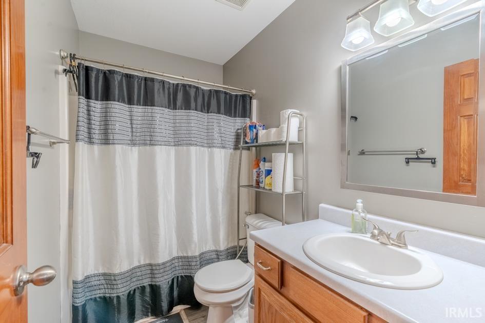 Full bath with vanity and a shower with shower curtain