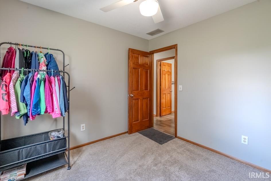 Bedroom featuring light carpet and a ceiling fan