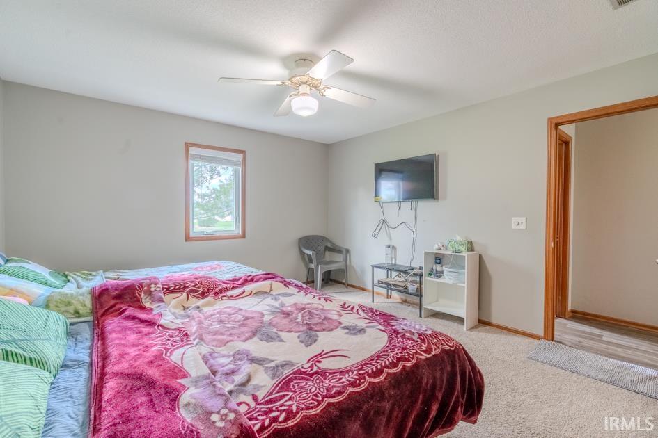 Bedroom featuring light colored carpet and a ceiling fan