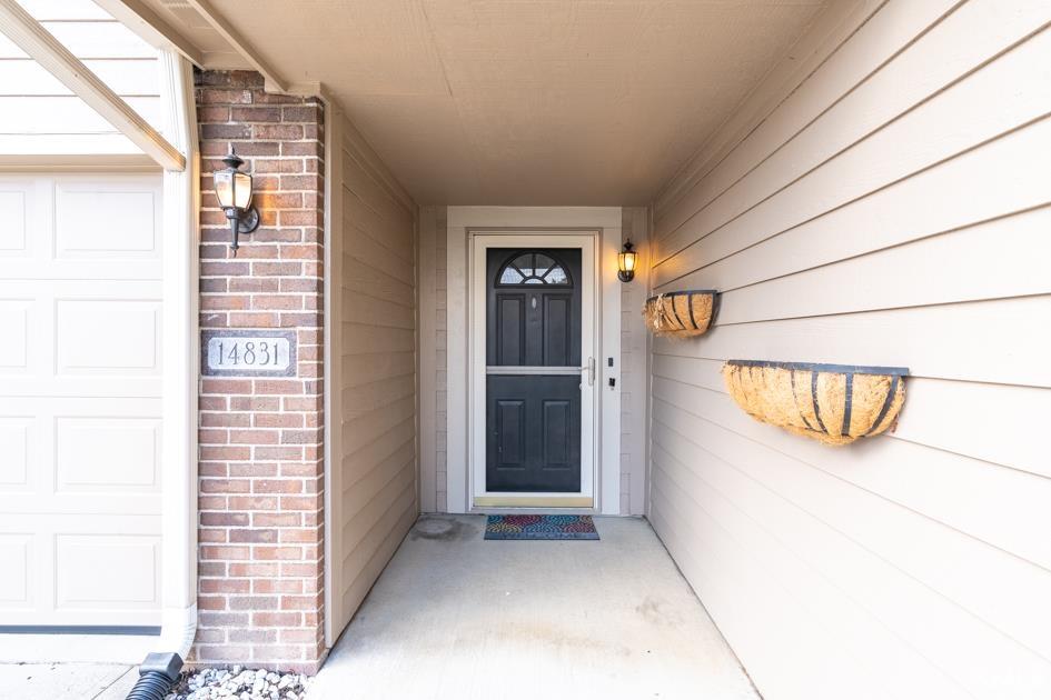 Property entrance featuring brick siding and covered porch