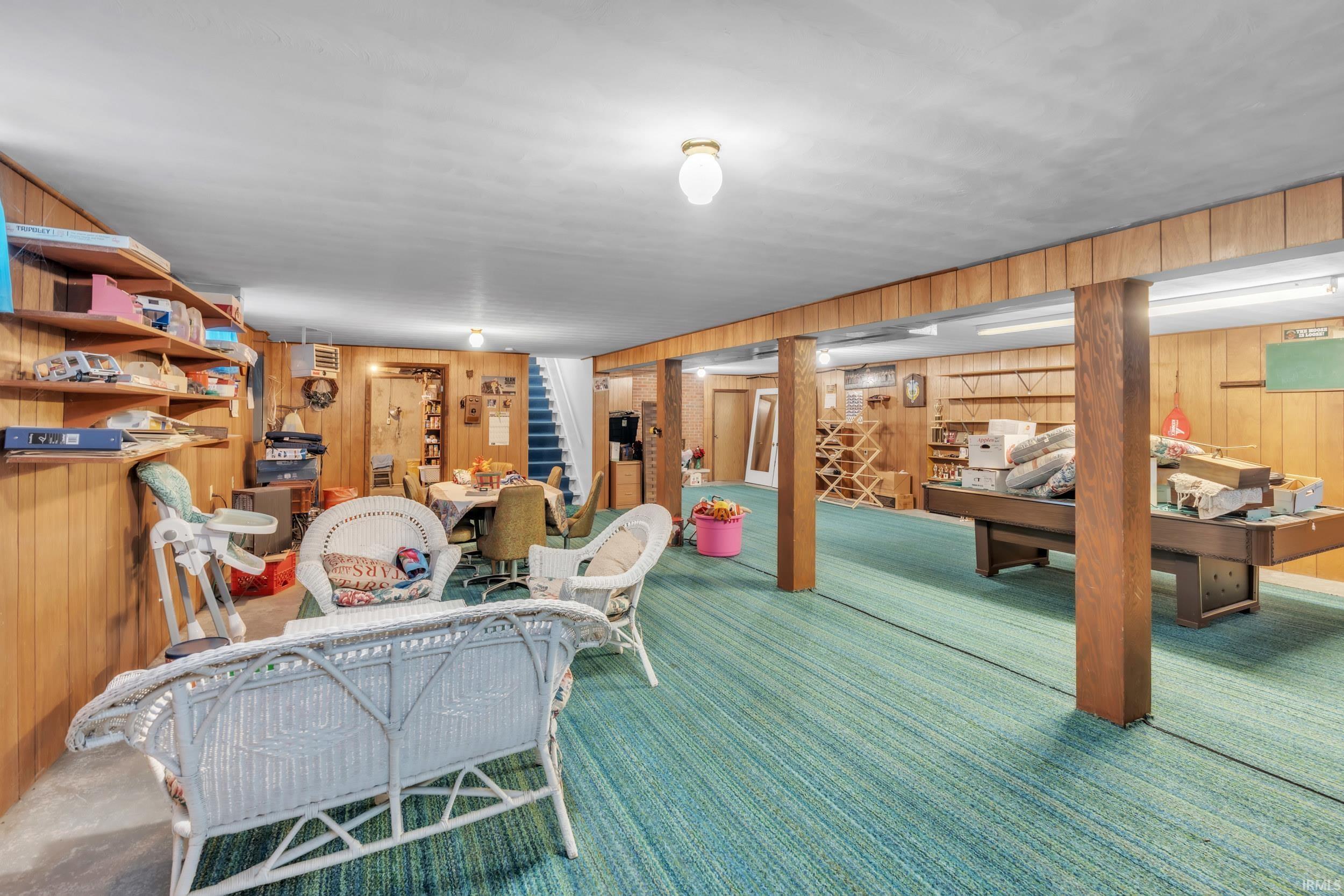 Interior space with wood walls, carpet, and a heating unit