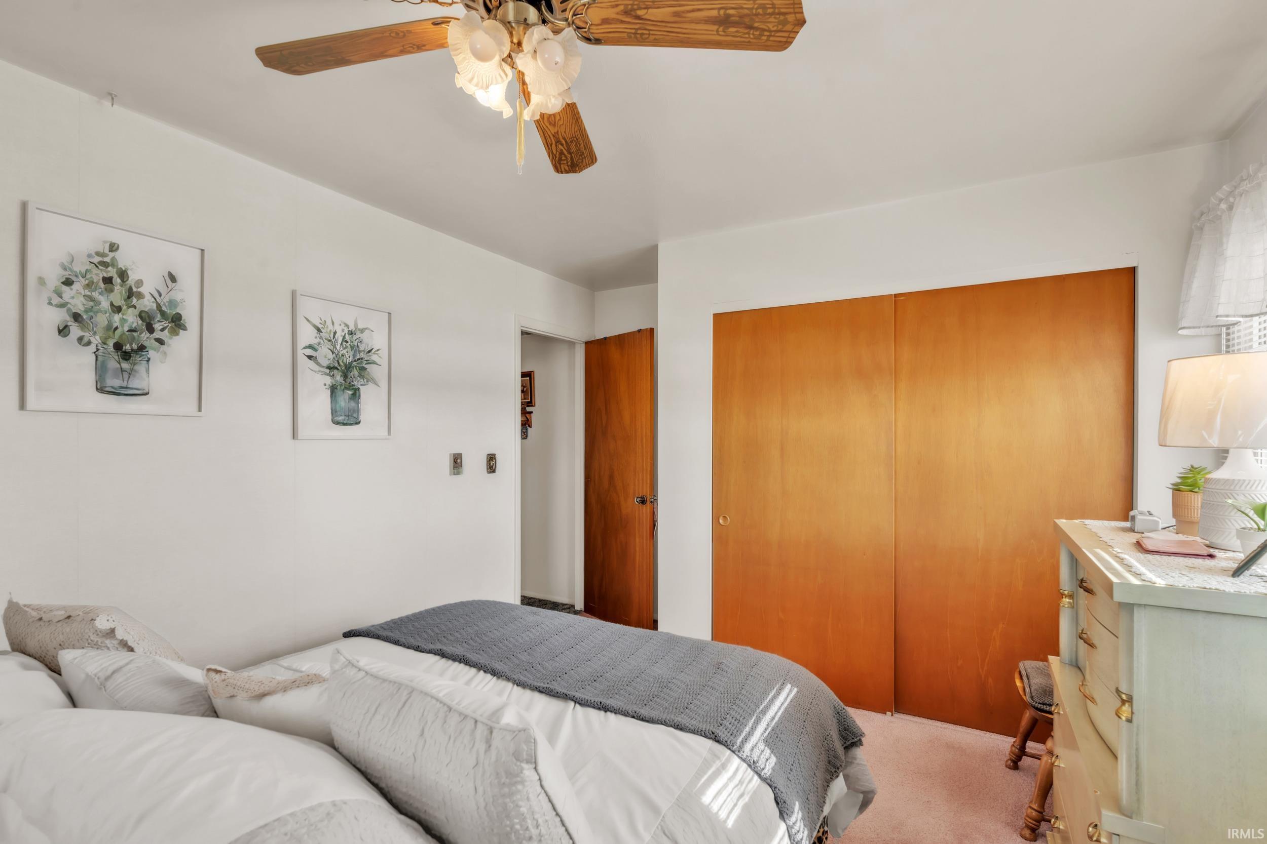 Carpeted bedroom featuring a closet and a ceiling fan