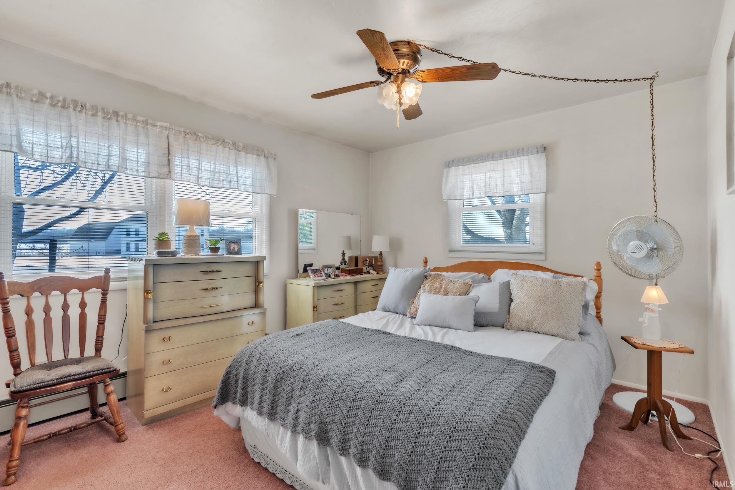 Bedroom with light colored carpet and ceiling fan
