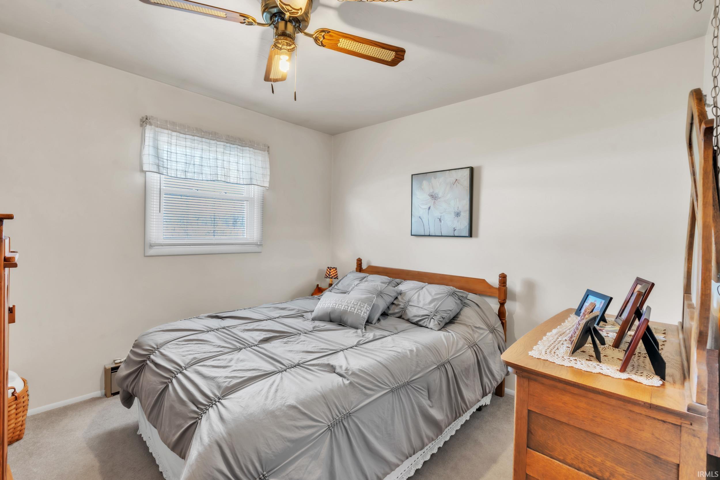 Bedroom featuring a ceiling fan and carpet