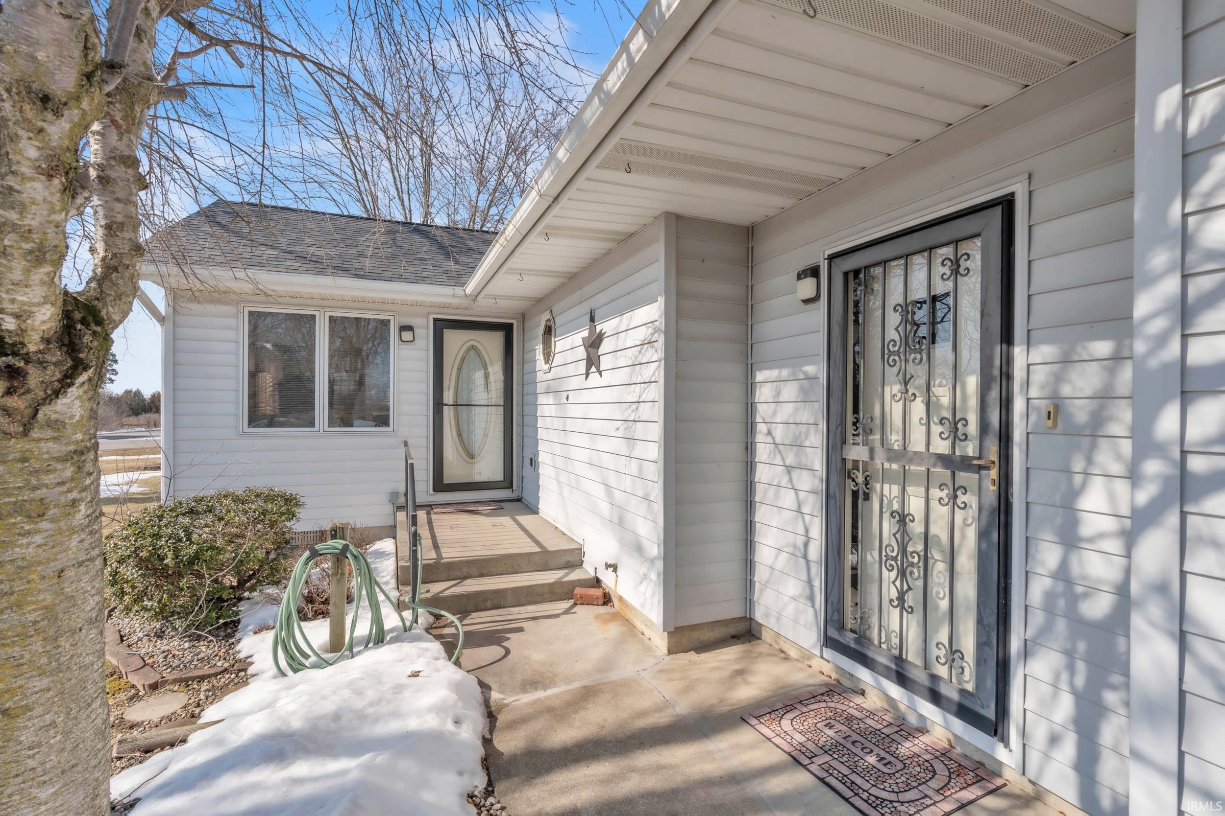 Entrance to property with a shingled roof