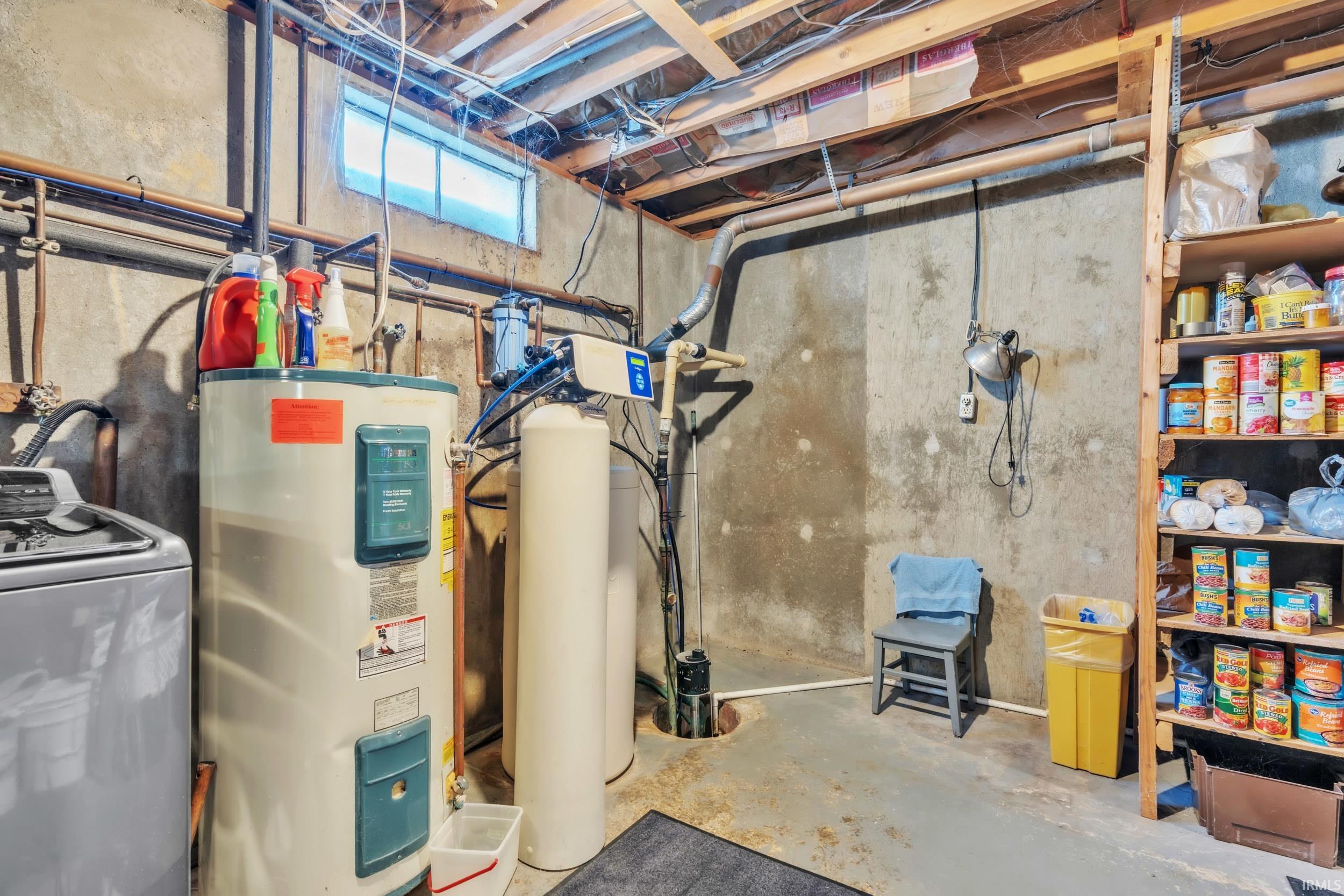 Basement featuring washer / clothes dryer, electric water heater, and a water softener system