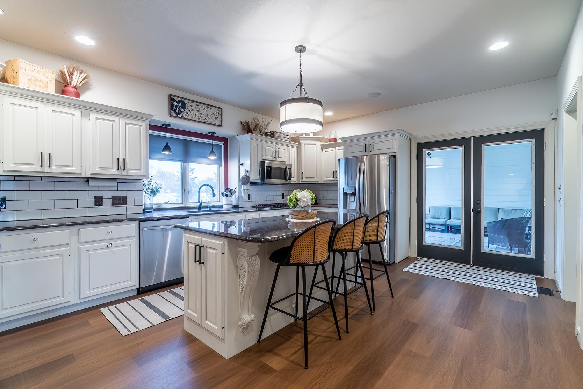 Kitchen with dark stone counters, a breakfast bar, stainless steel appliances, a center island, and dark wood-type flooring