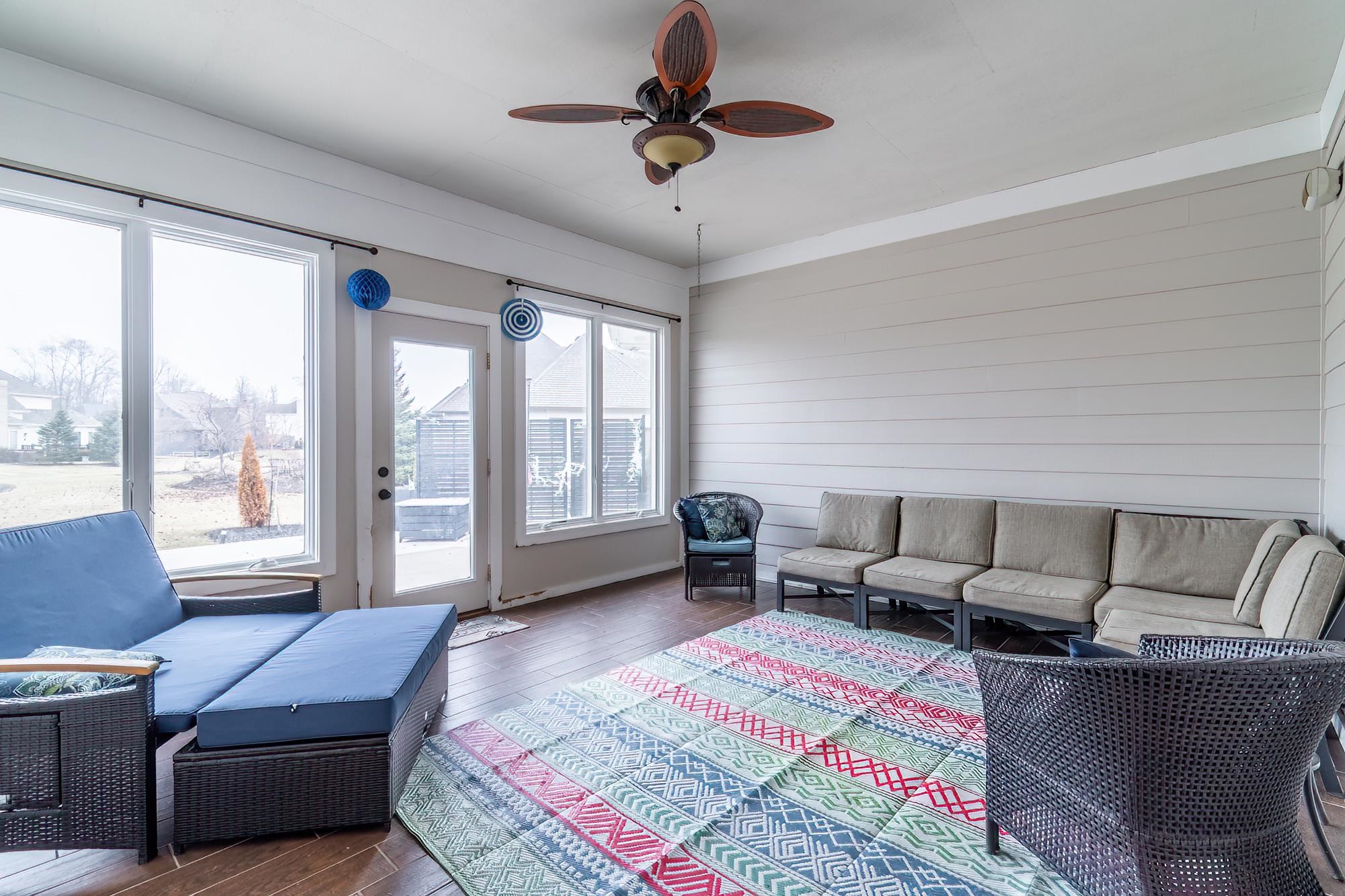 Living area with ceiling fan and dark wood-type flooring