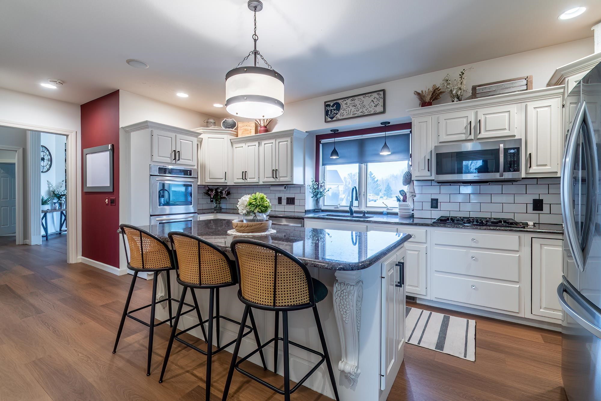 Kitchen with dark stone counters, a breakfast bar area, a center island, and dark wood-style flooring