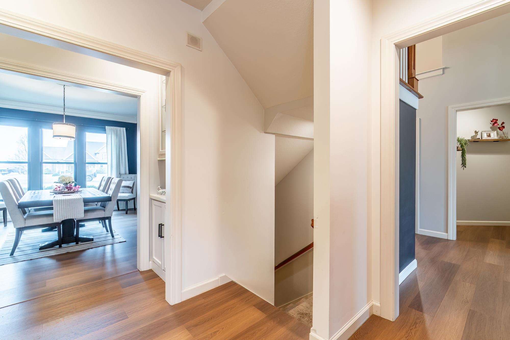 Corridor with light wood-style flooring and an upstairs landing