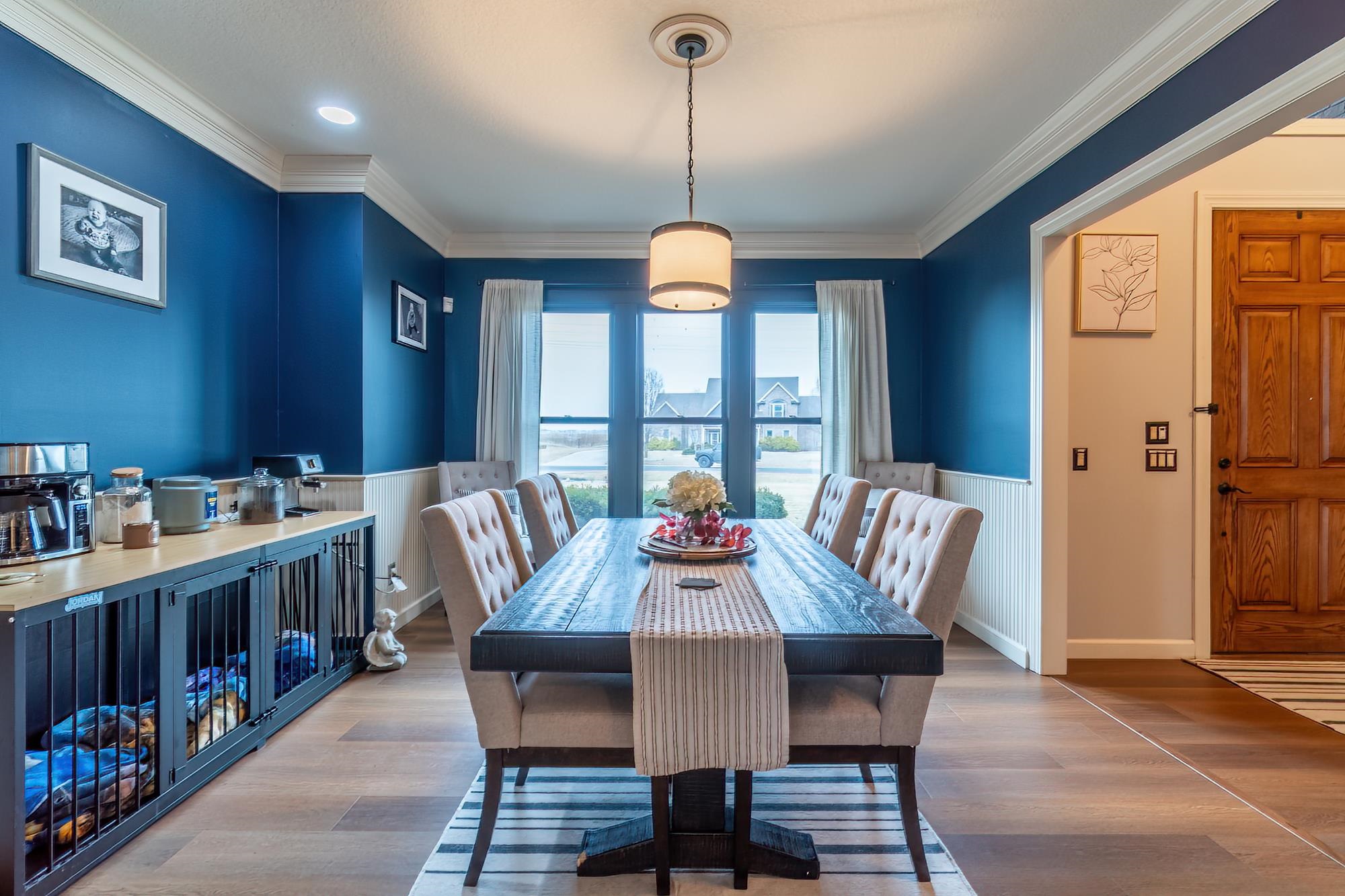 Dining area with wainscoting, wood finished floors, and crown molding