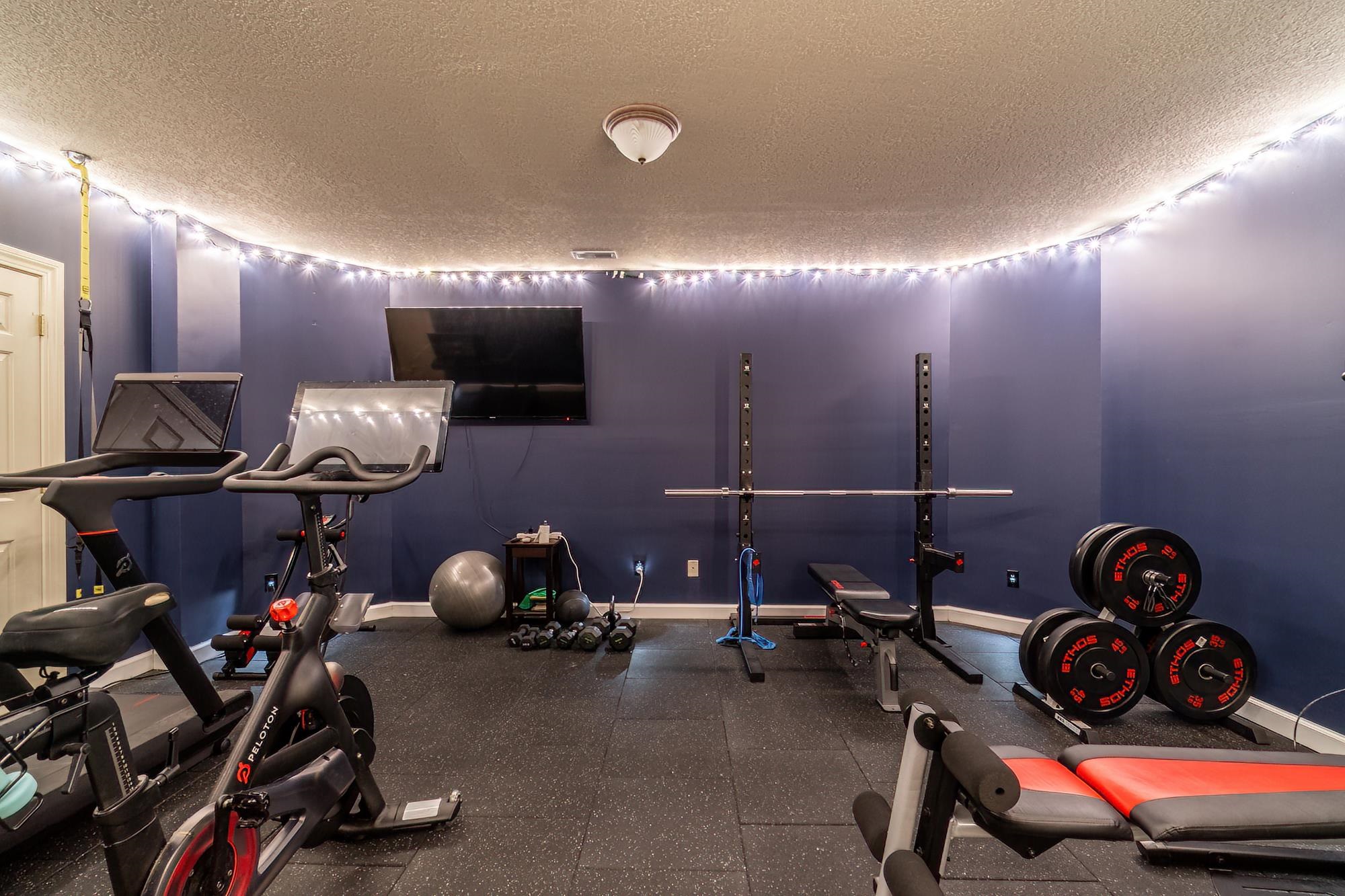 Exercise area featuring rubber floors and a textured ceiling