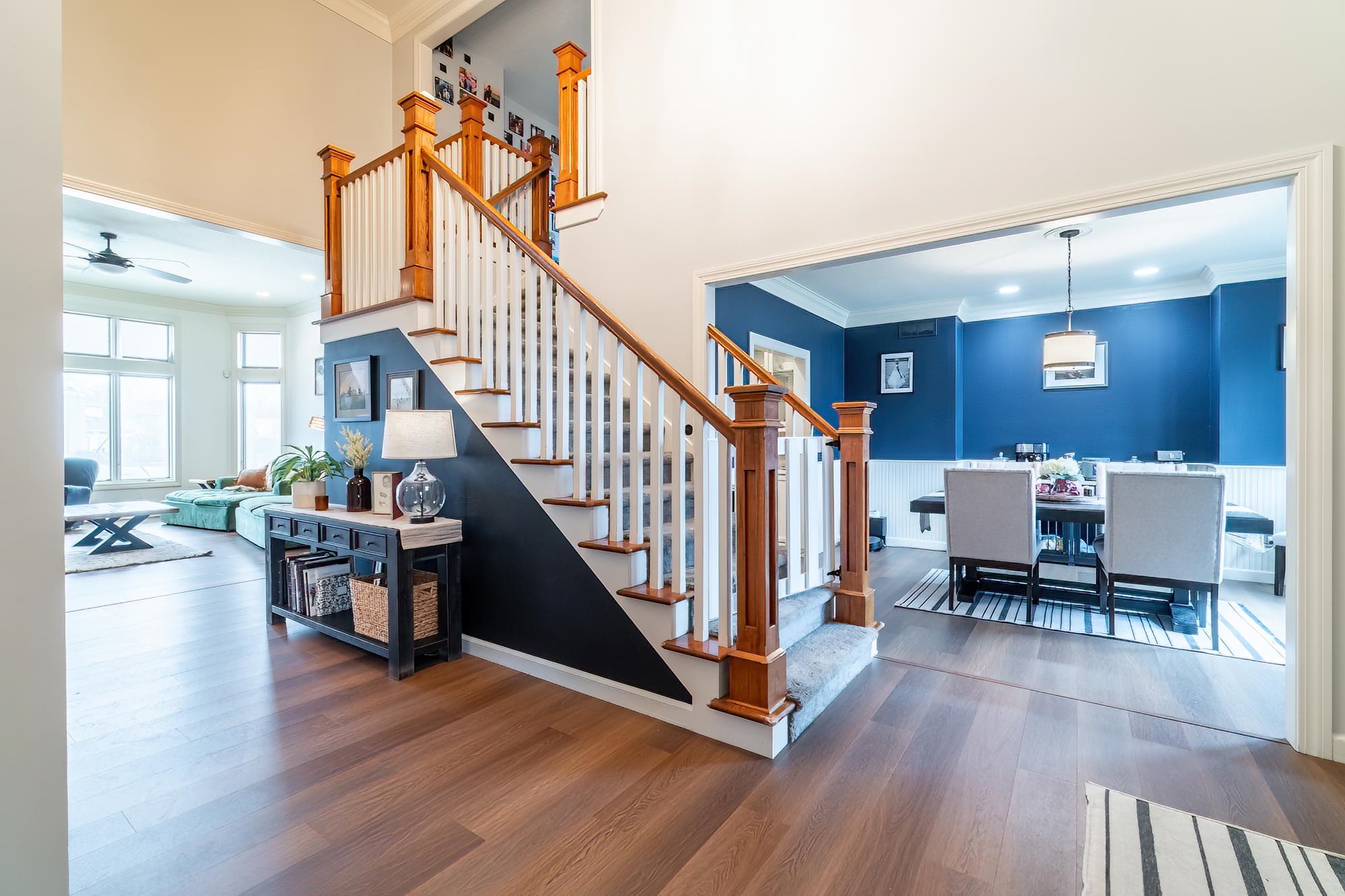 Staircase featuring crown molding, wood finished floors, ceiling fan, recessed lighting, and a high ceiling