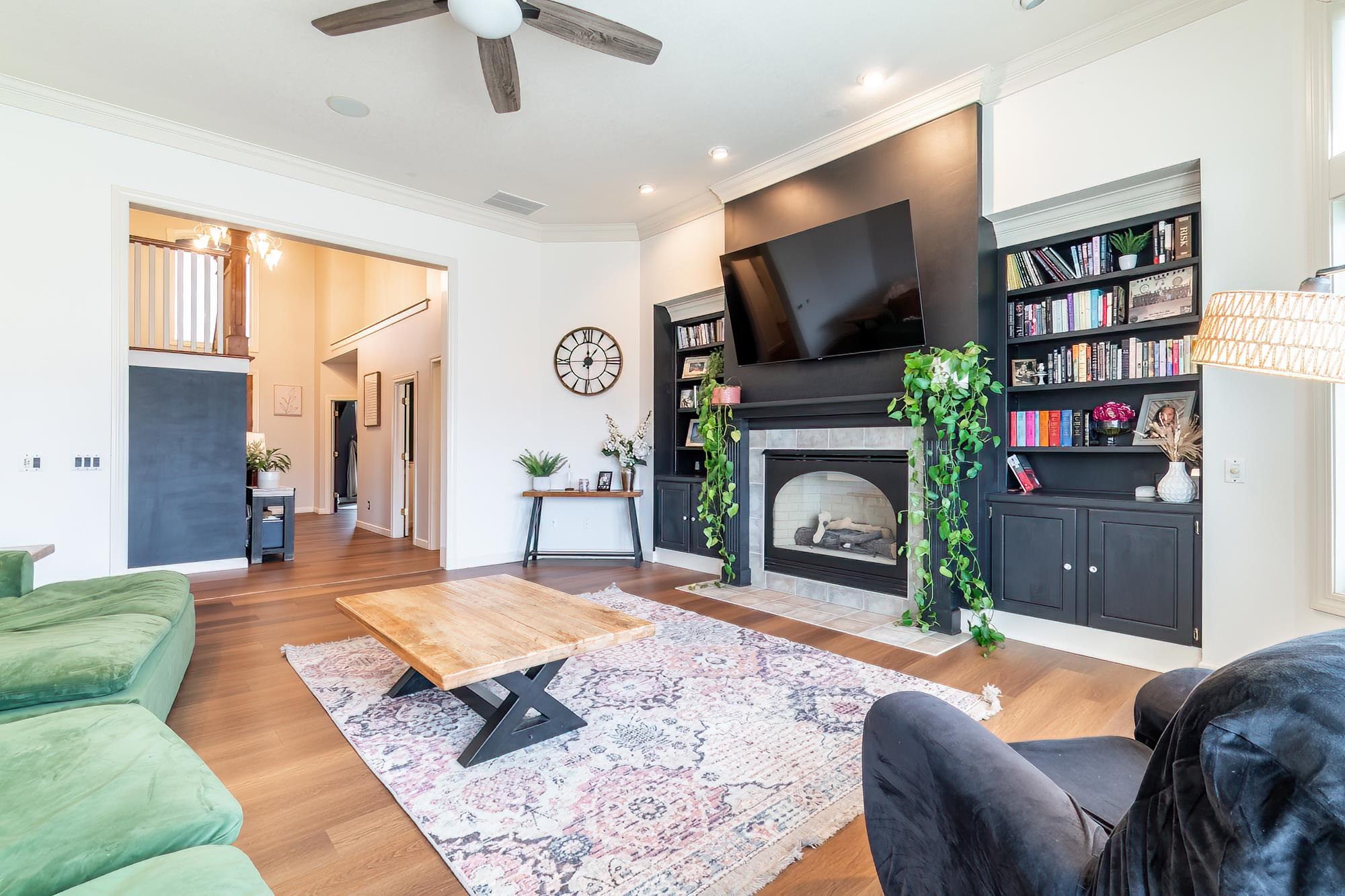 Living room featuring wood finished floors, a tile fireplace, a ceiling fan, ornamental molding, and recessed lighting