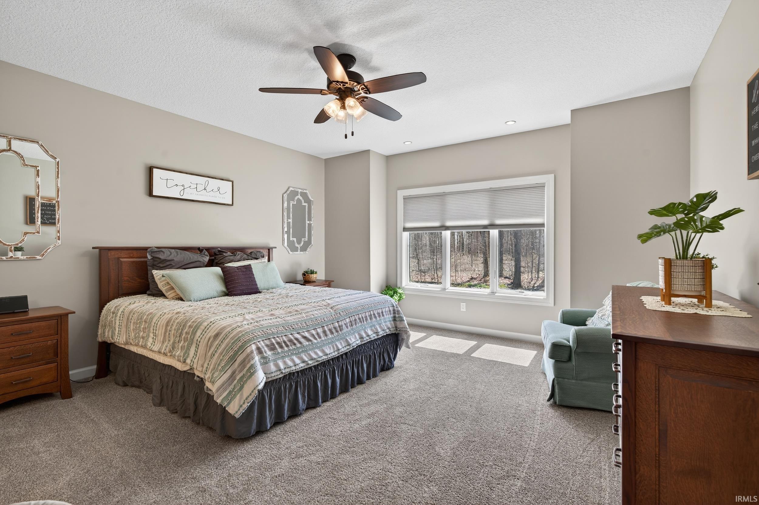 Bedroom with carpet, ceiling fan, and a textured ceiling