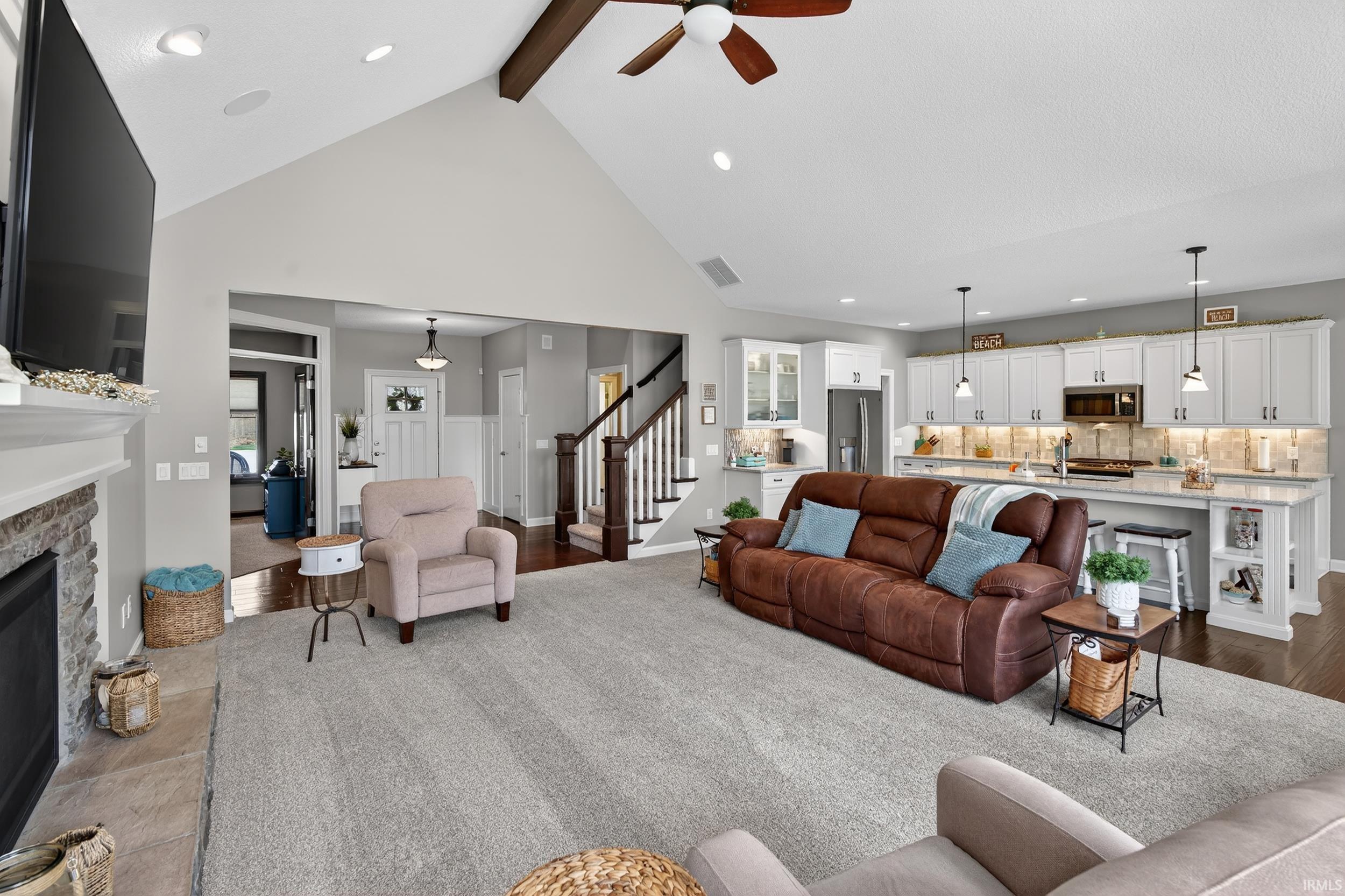 Living room with a ceiling fan, recessed lighting, and a fireplace