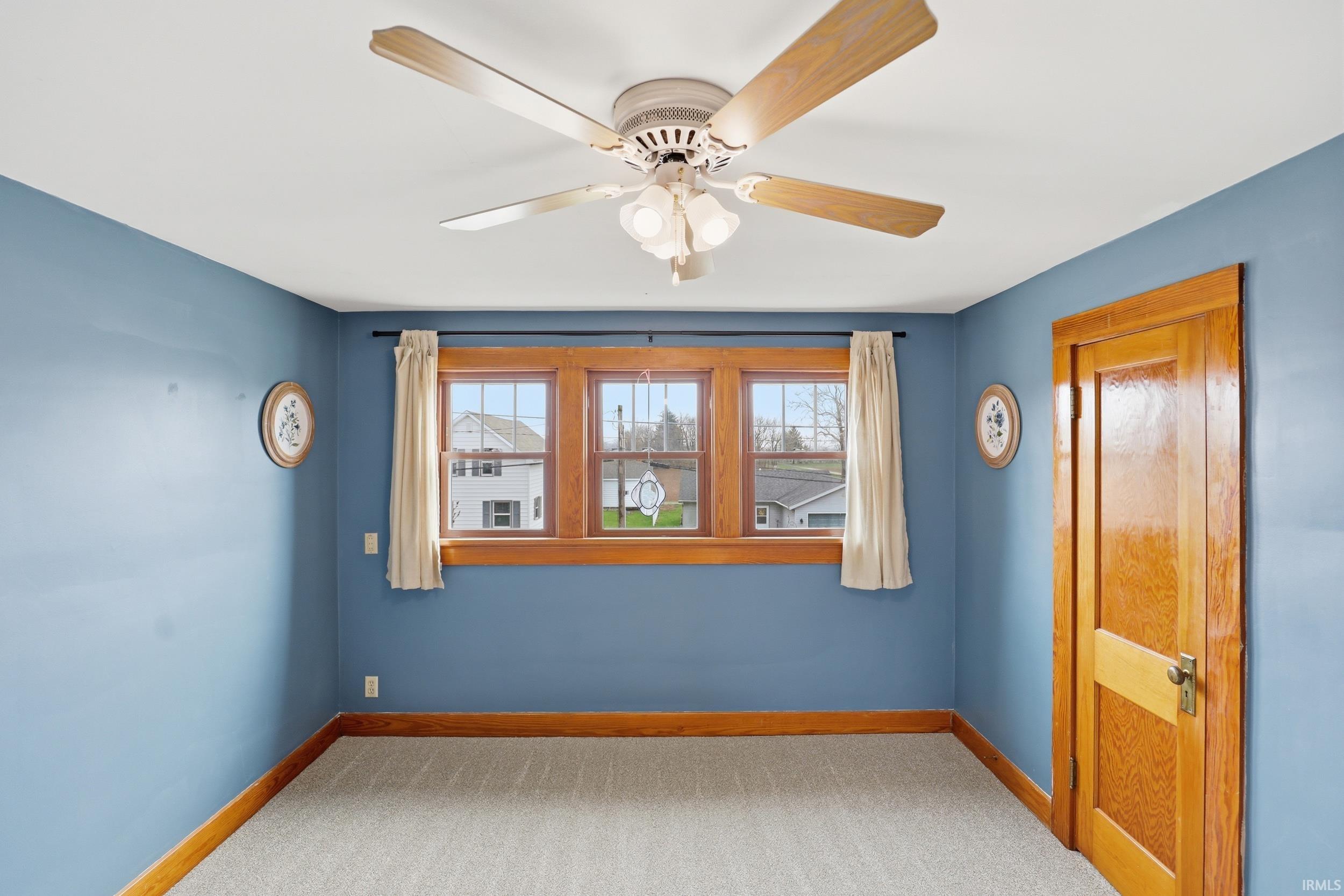 Unfurnished room featuring light colored carpet and a ceiling fan