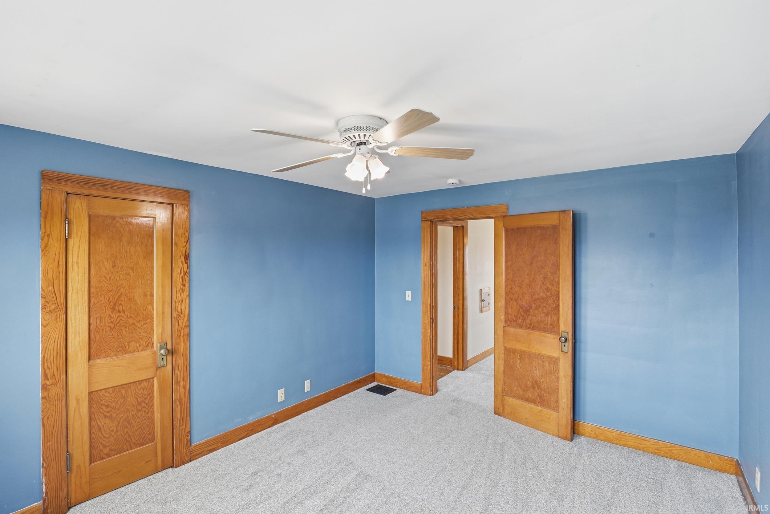 Unfurnished bedroom featuring ceiling fan and light carpet