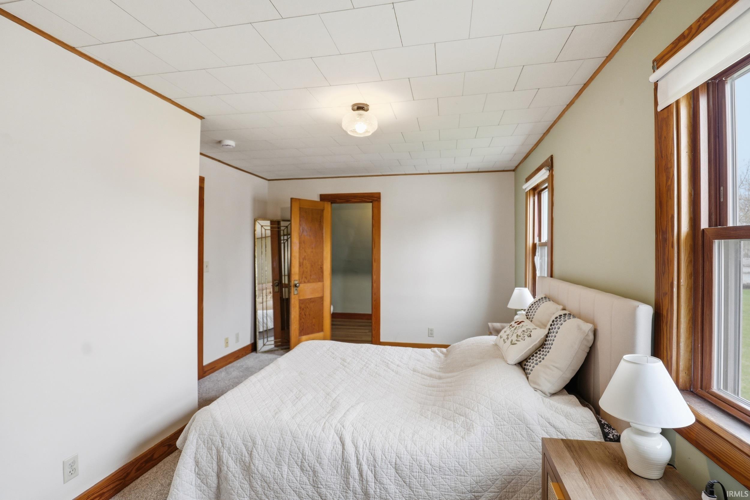 Bedroom featuring carpet flooring and crown molding