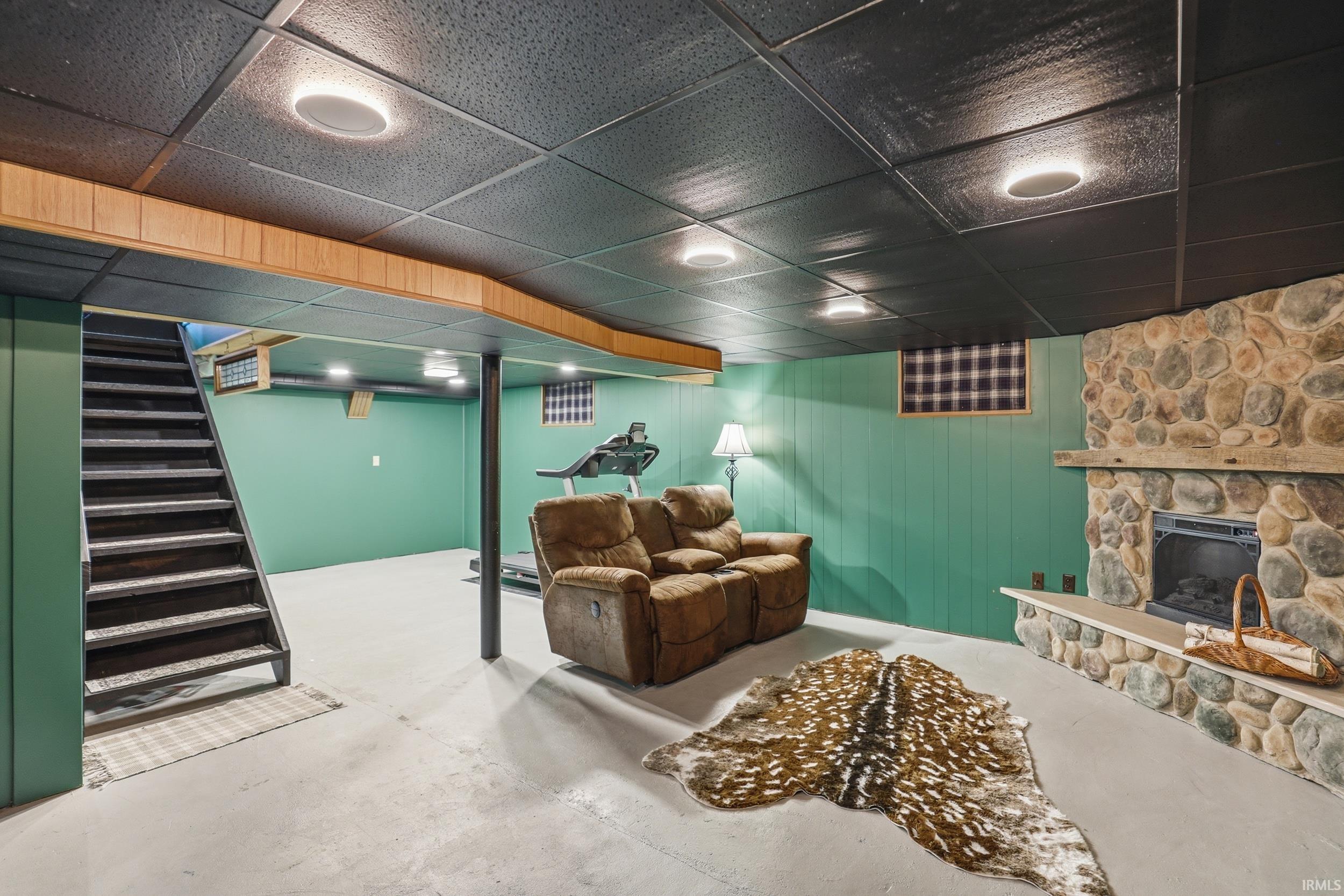 Finished below grade area featuring a fireplace and a drop ceiling