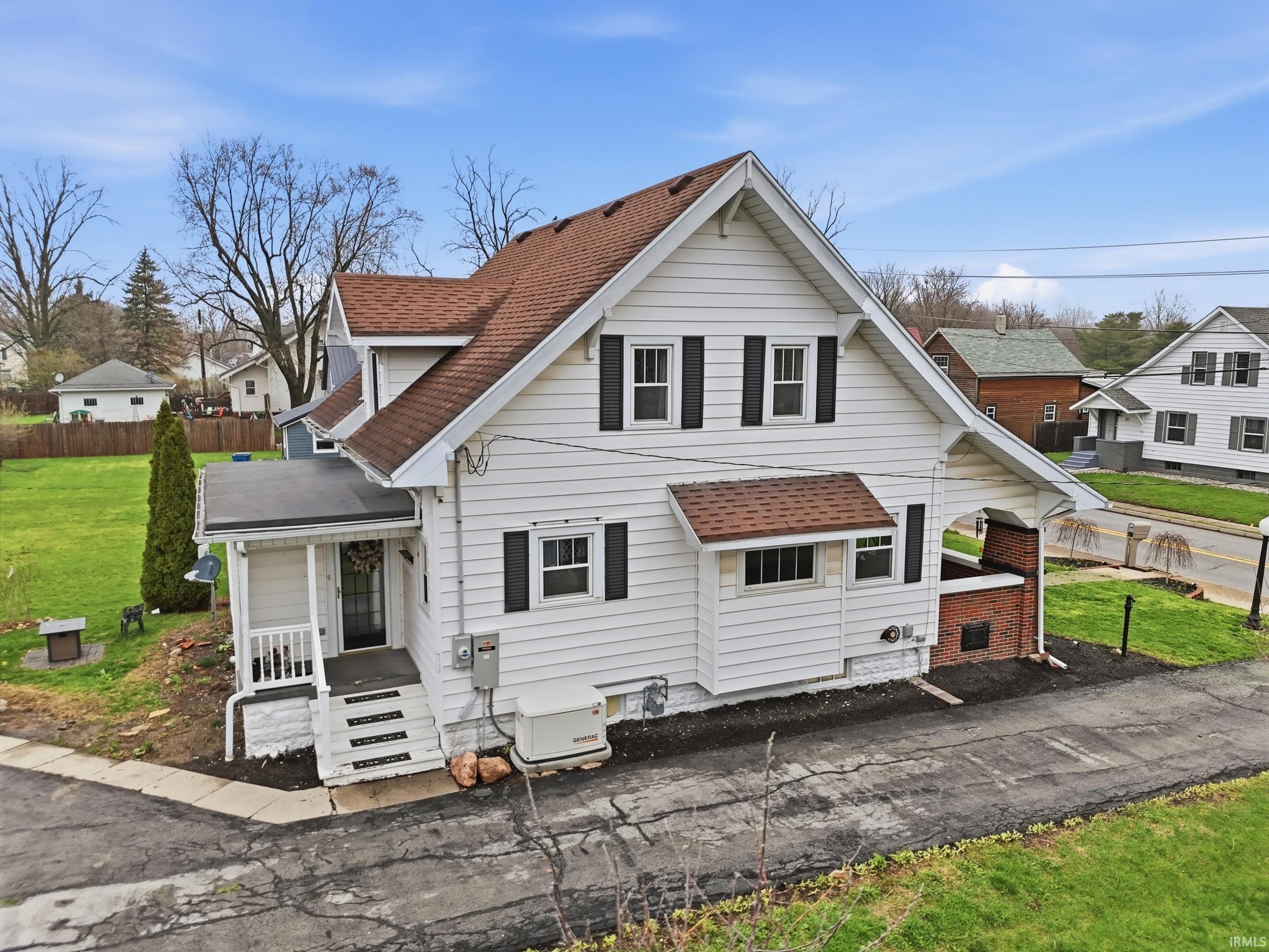View of front of home with a shingled roof and a porch